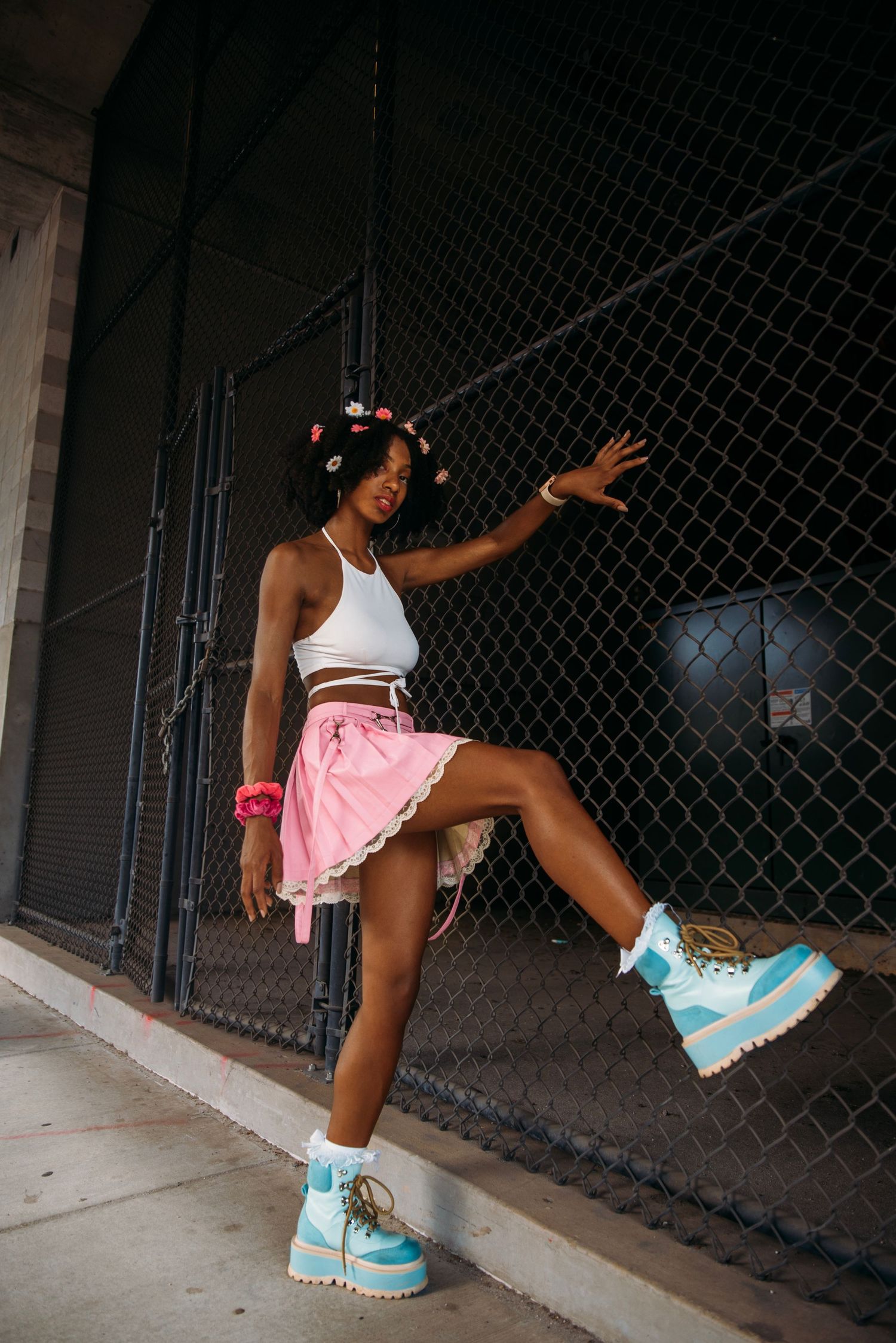 Close-up shots of light blue boots and pink skirt against dark background.