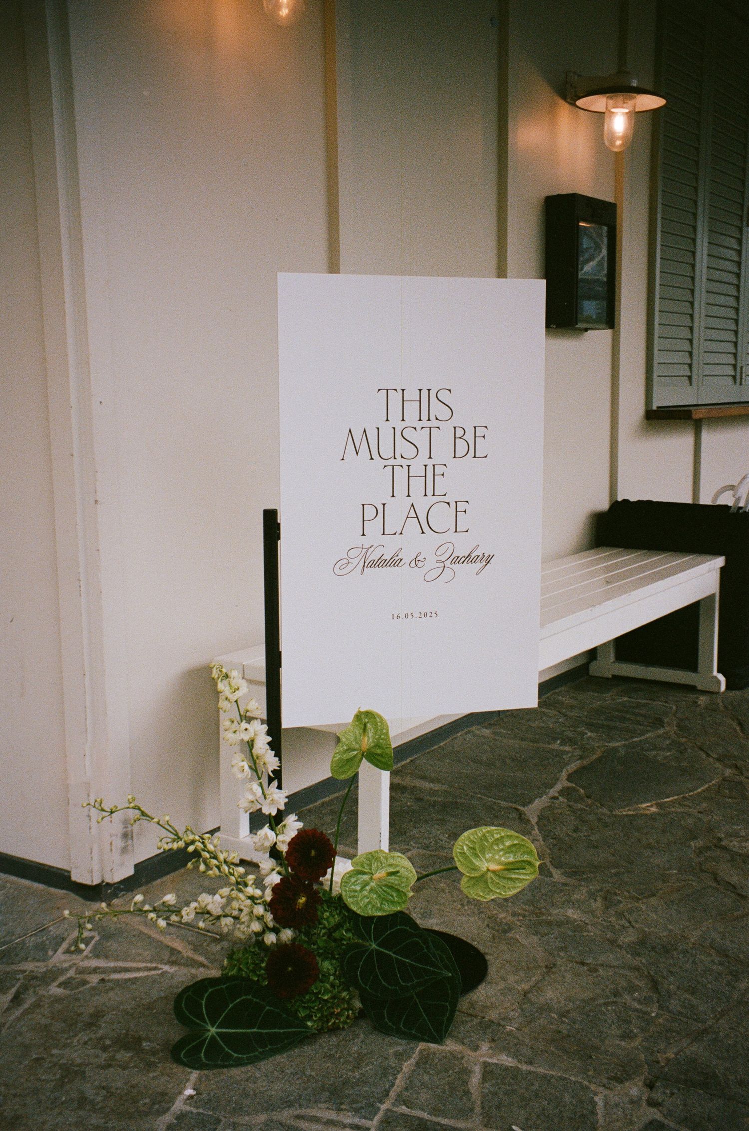 Decorative wall signage reading 'This Must Be The Place' with minimalist floral arrangements.