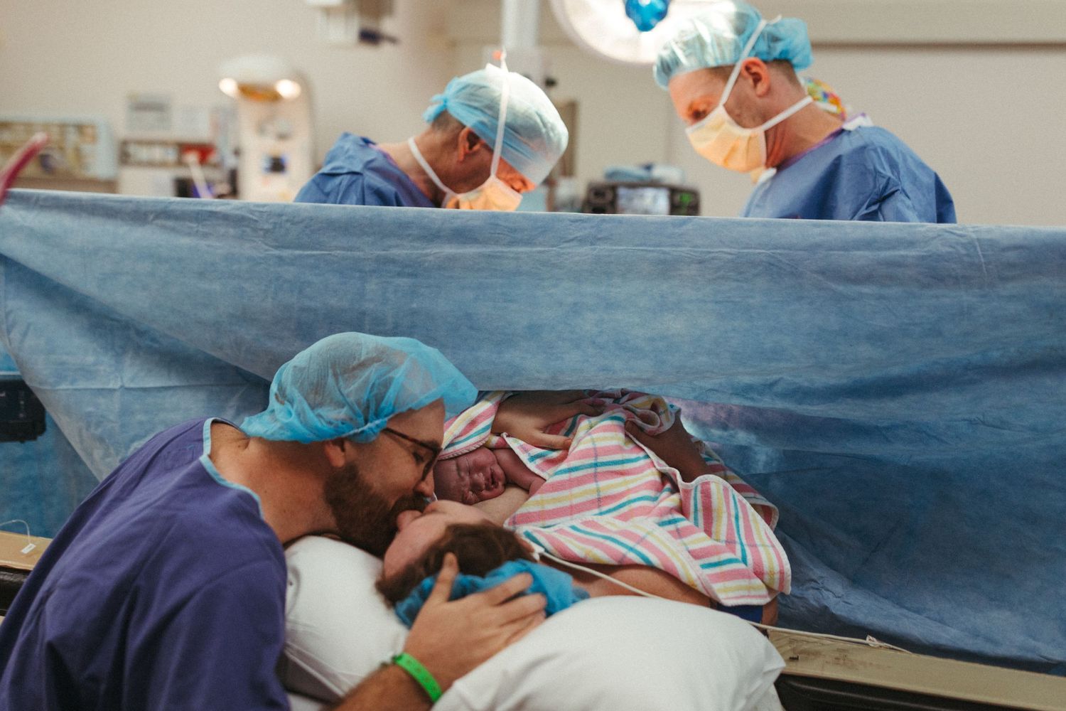 Medical team in surgical gowns and masks performing an operation in a hospital operating room.