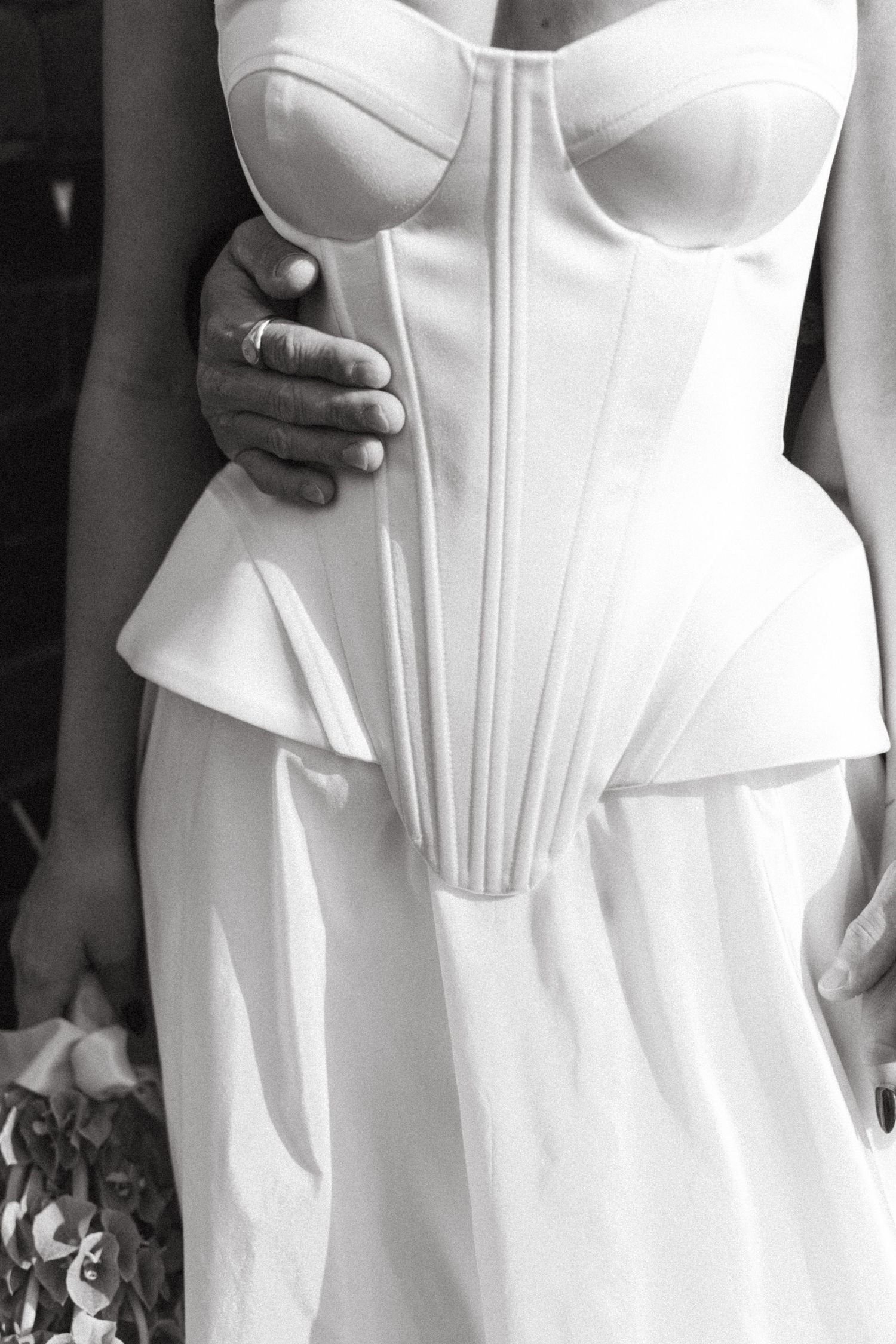 Close-up detail of structured white wedding dress bodice with corset-style boning.