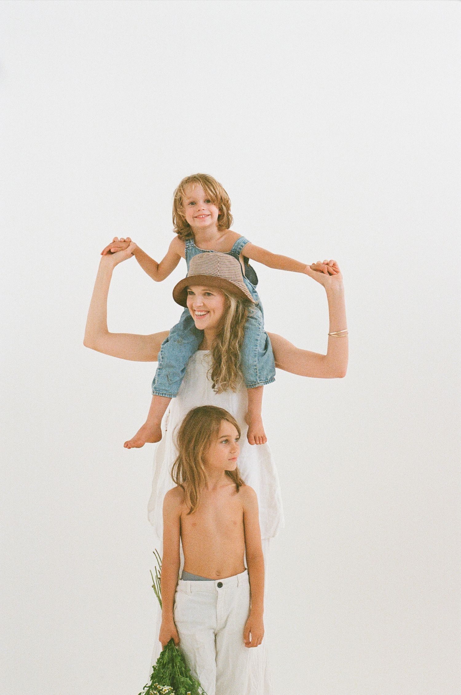 Three figures in casual clothing posed together against a white background.