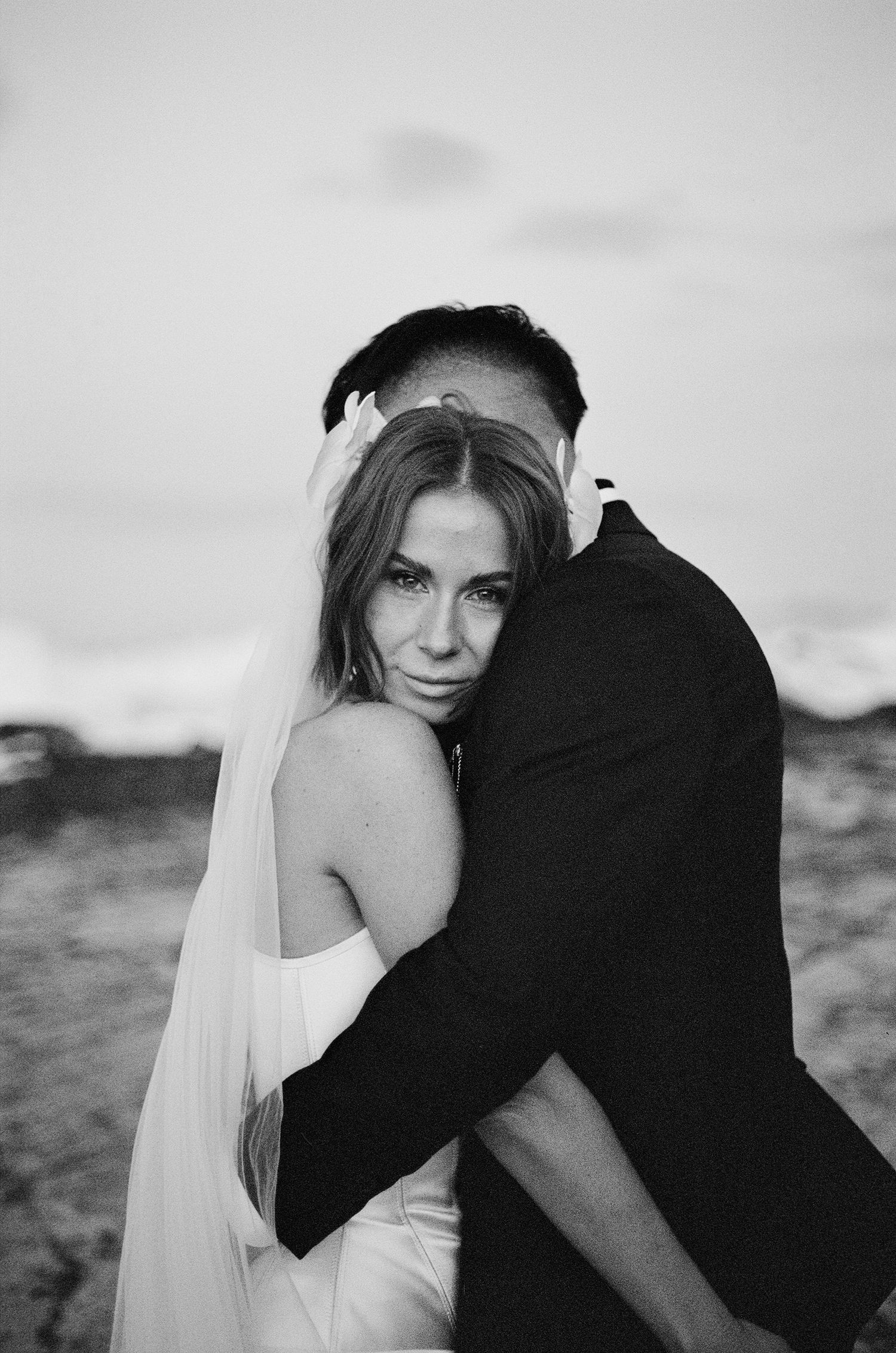 Romantic black and white series of intimate moments between a bride and groom during their beachside wedding photoshoot.