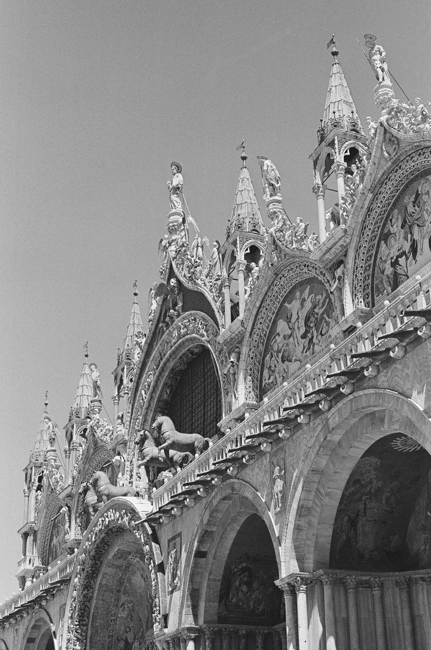Gothic architectural details of Saint Mark's Basilica facade with pointed arches and ornate spires.