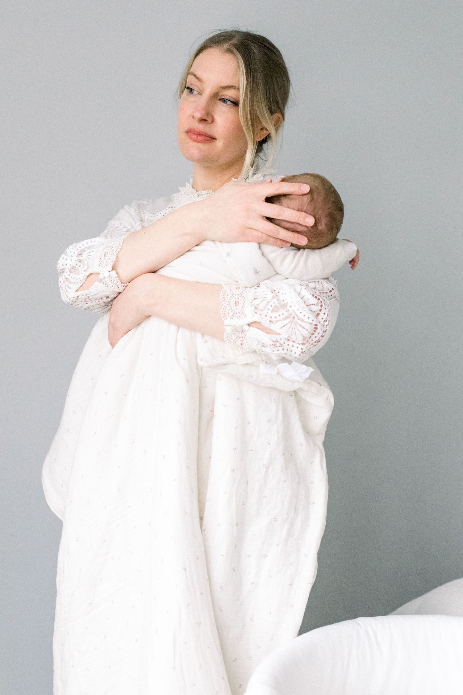 mother holding her newborn baby on her arms during a newborn photo session in London.