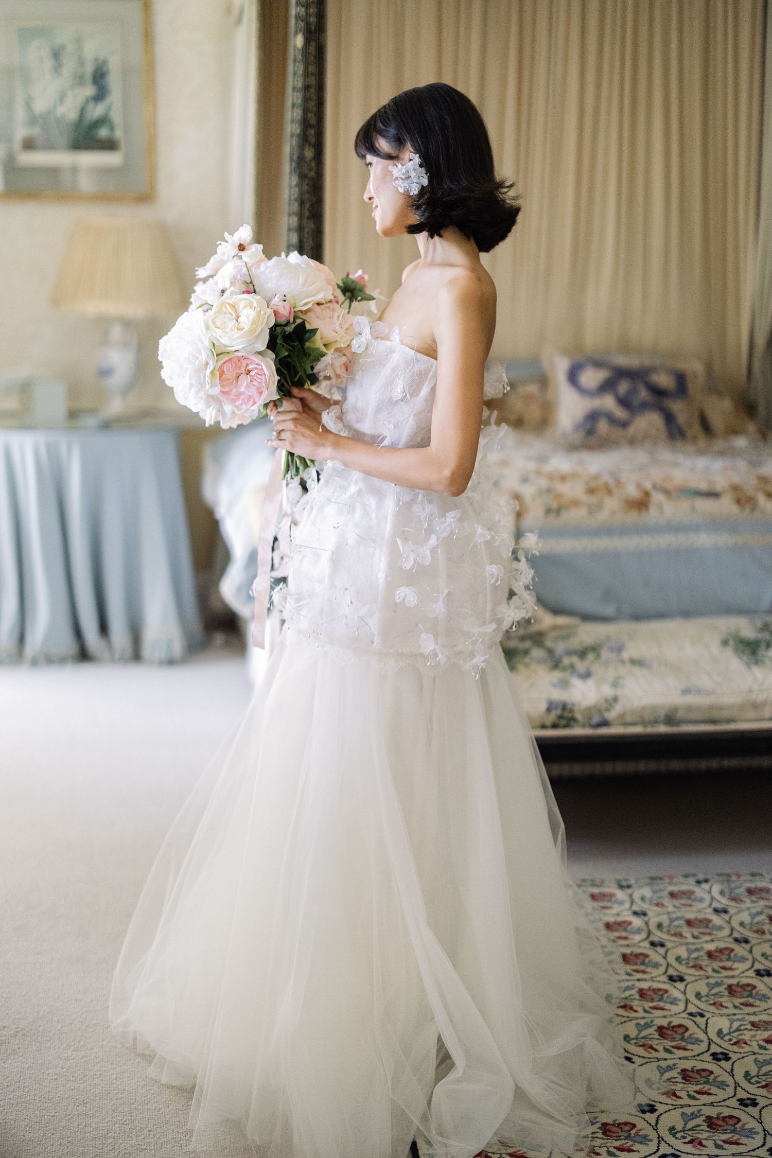Bride in romantic tulle wedding gown holding pastel bouquet, fine art bridal portrait at luxury UK venue by Miriam Caterina Wahl Photography