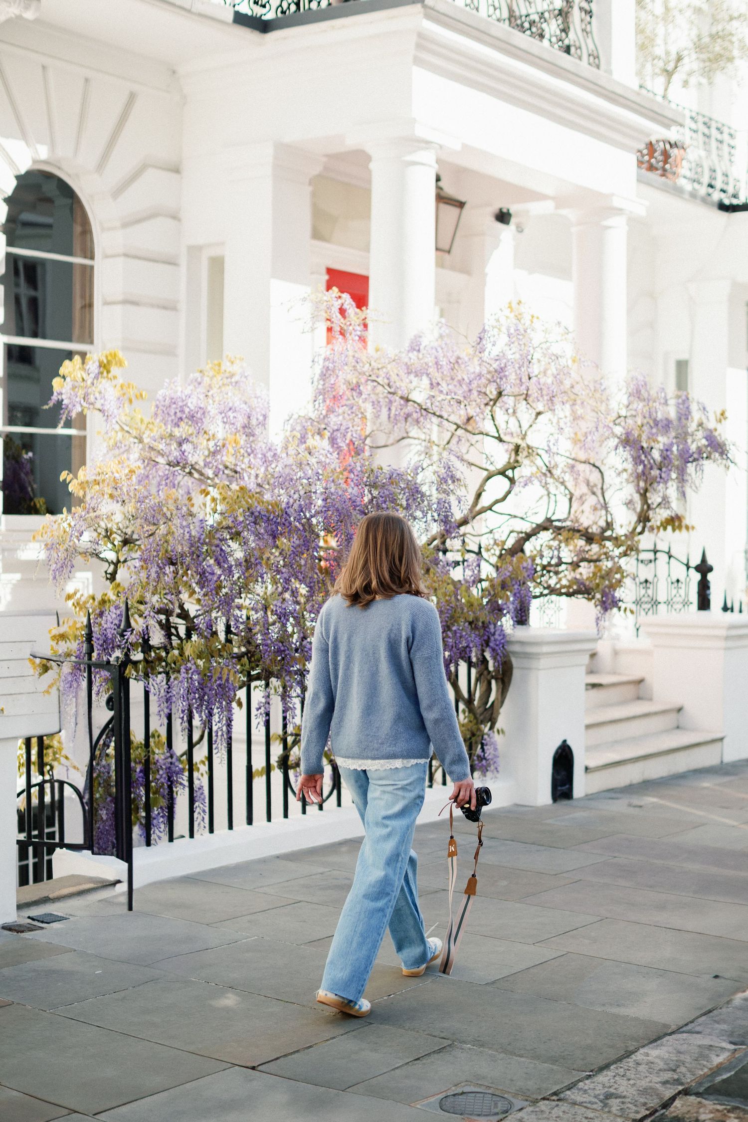 Miriam C Wahl walking through asunny London street with her camera