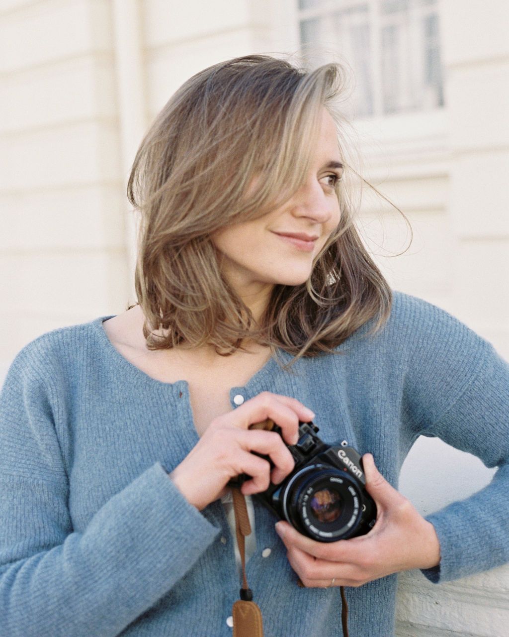 Headshot of Miriam Caterina Wahl smiling and holding her film camera