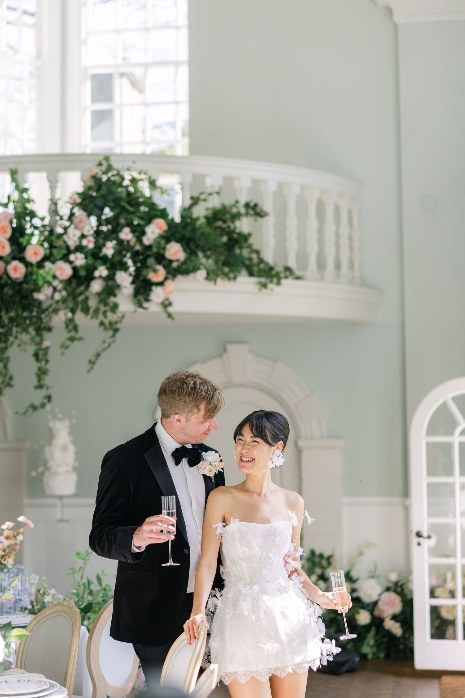 Bride and Groom standing together during their luxurious reception at a stately home in England. Toasting with champagne
