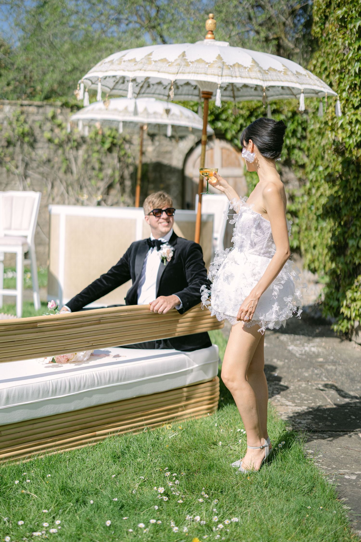 Bride and Groom enjoying a glass of champagne in the garden during their reception at the exclusive wedding venue Cornwell Manor