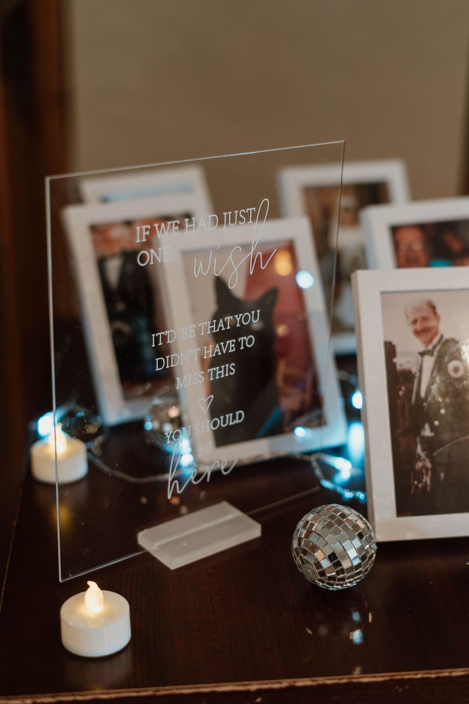 Wedding reception decor with illuminated acrylic signs and tealight candles creating ambient lighting.
