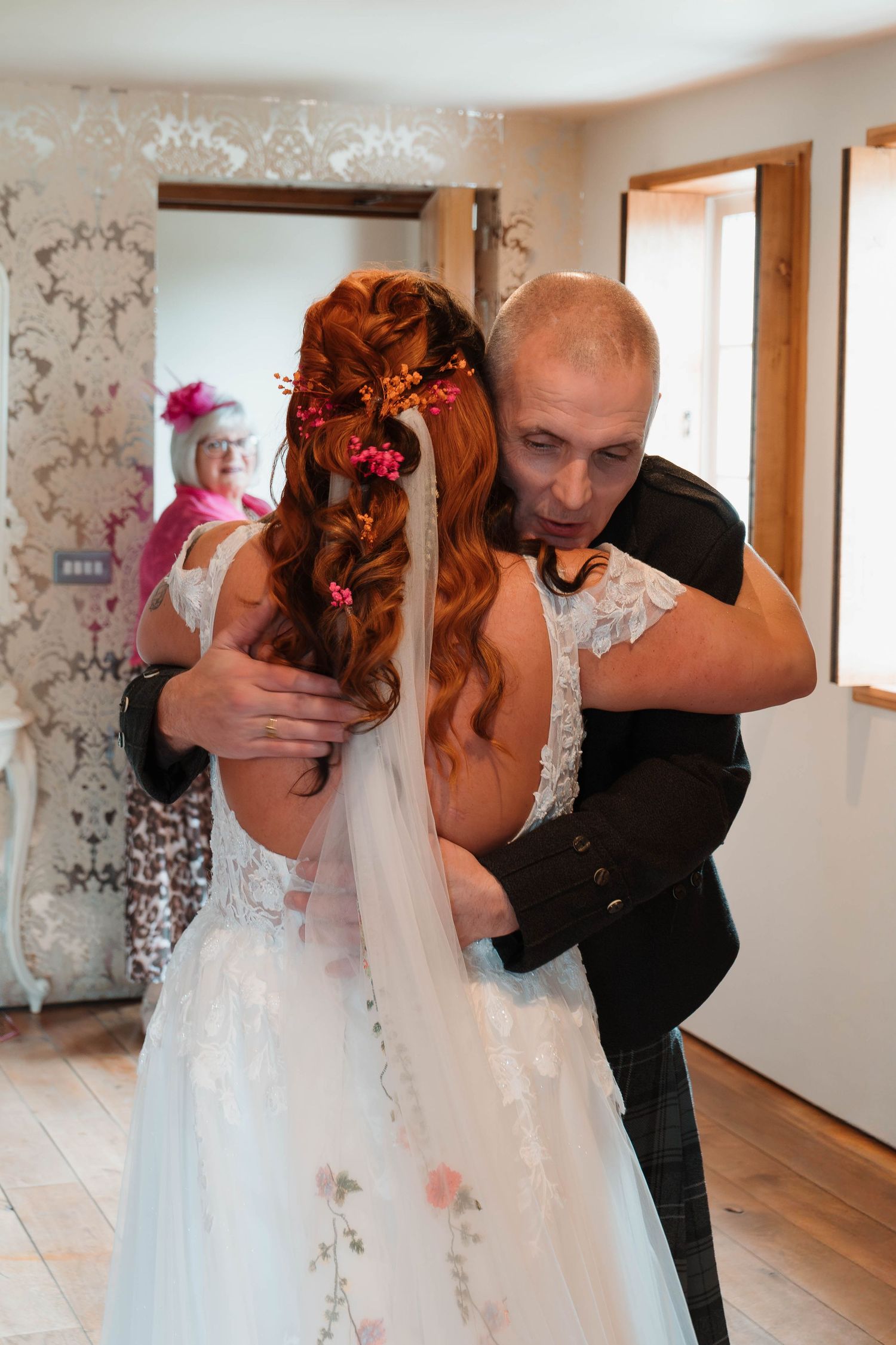 Intimate wedding moment captured in an indoor setting with natural window light.