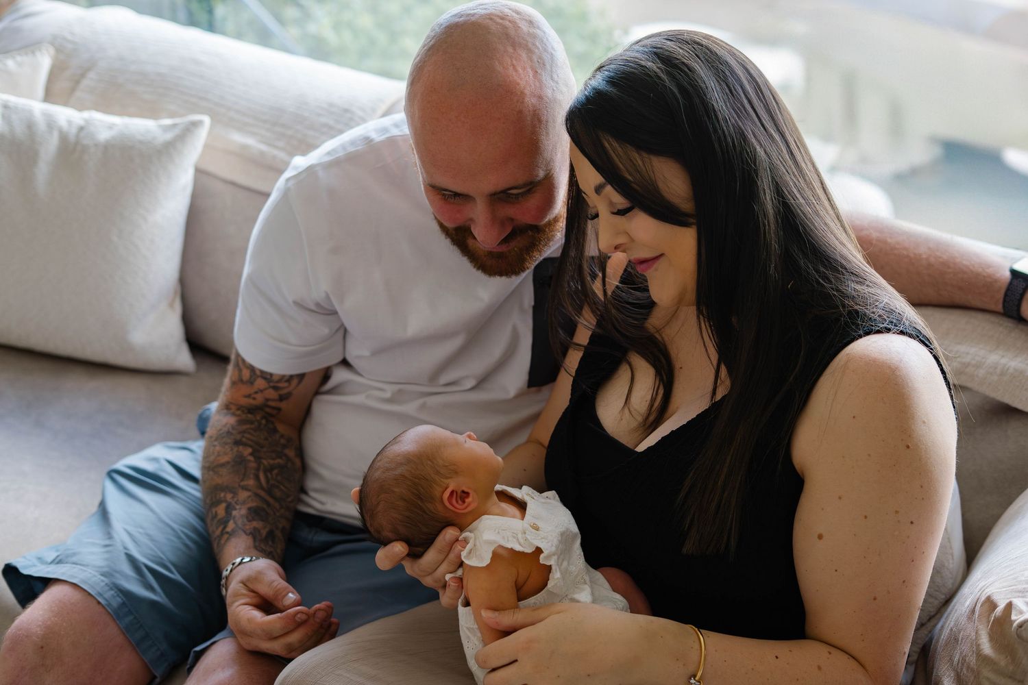 Candid lifestyle photography session showing tender family moments on a grey couch.