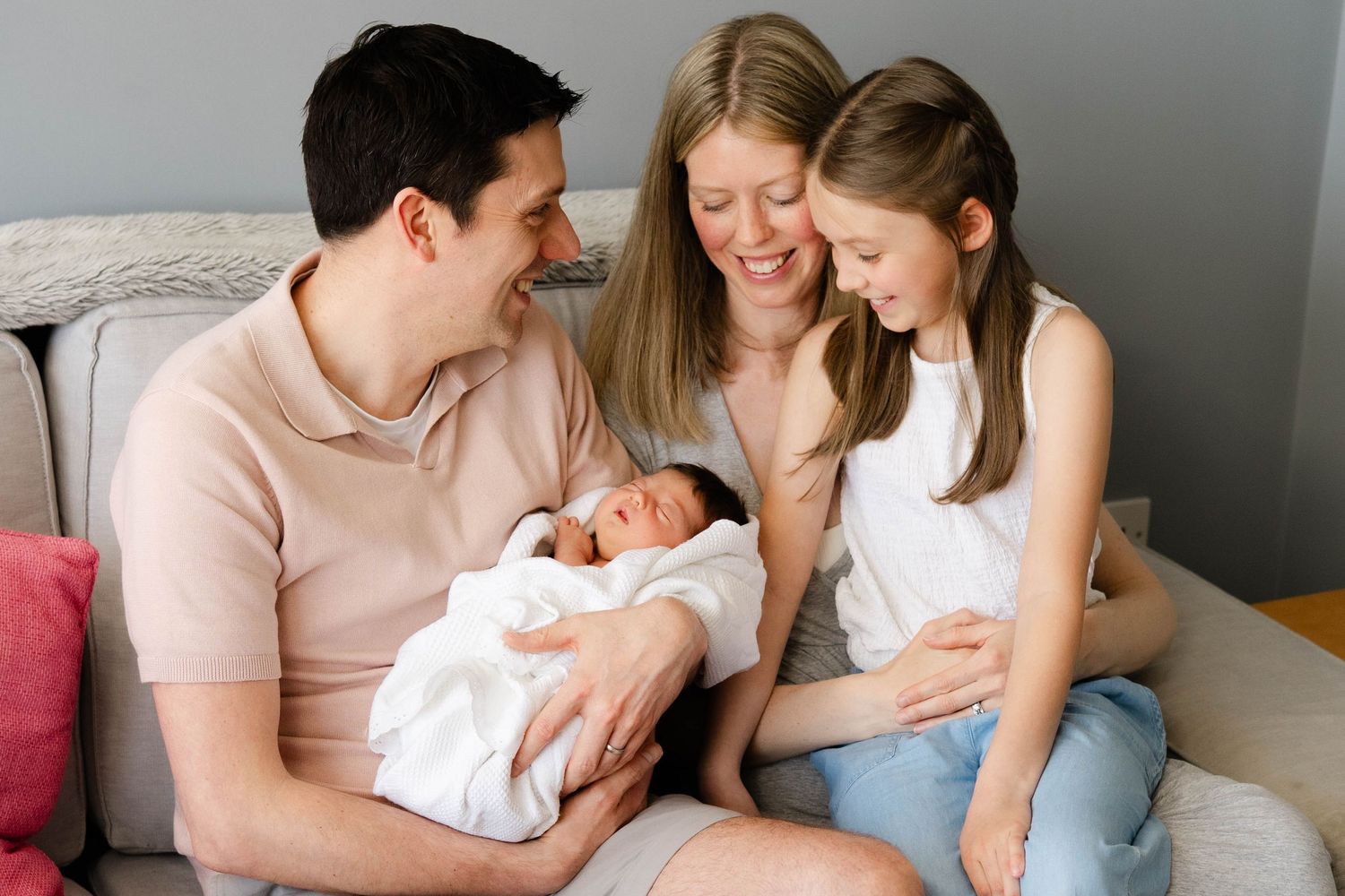A tender family moment captured in a series of intimate lifestyle photographs on a couch.