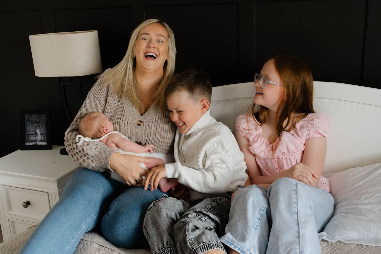 Candid family lifestyle photos showing siblings interacting on white couch.