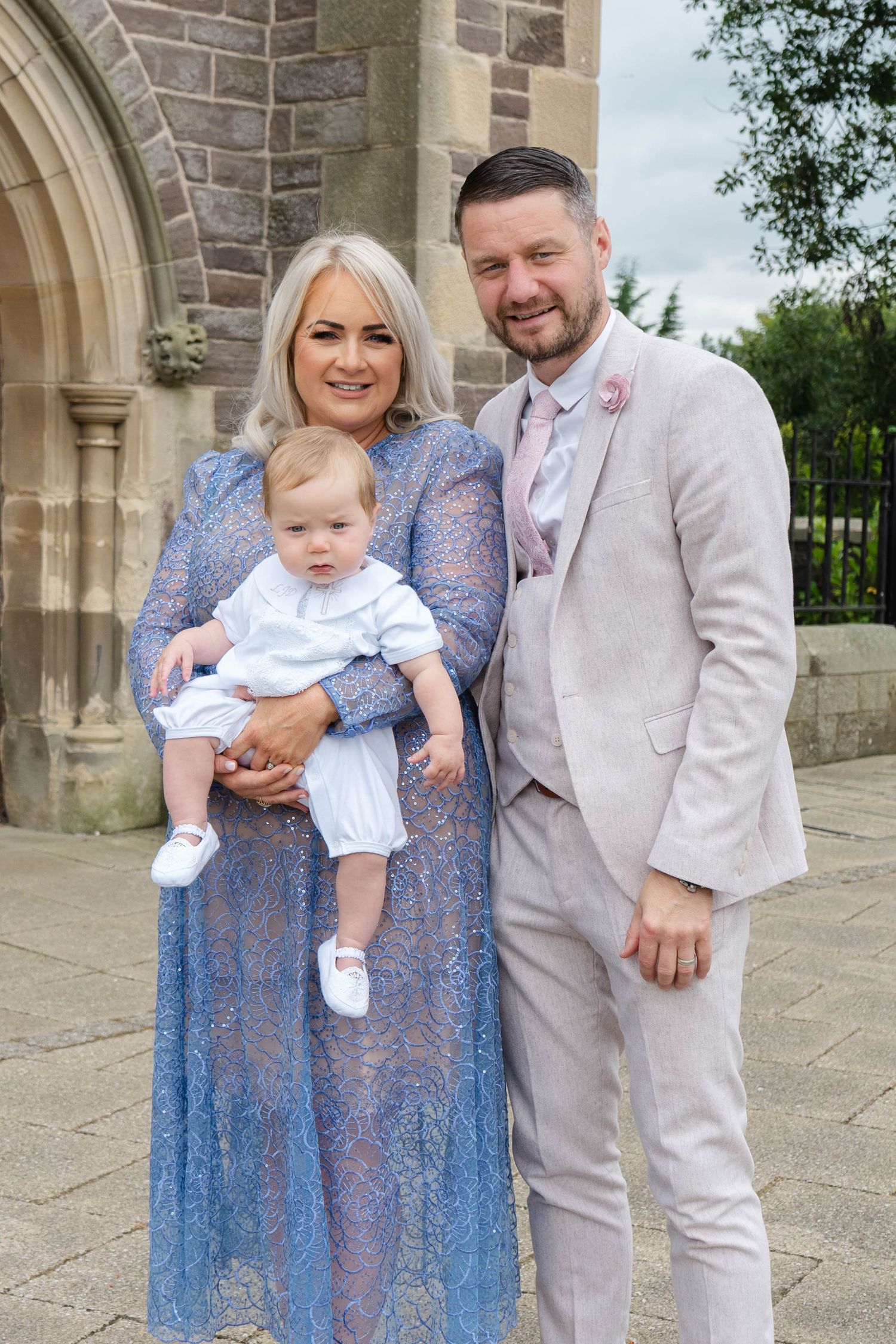 Outdoor family portraits against the backdrop of a stone church architecture.