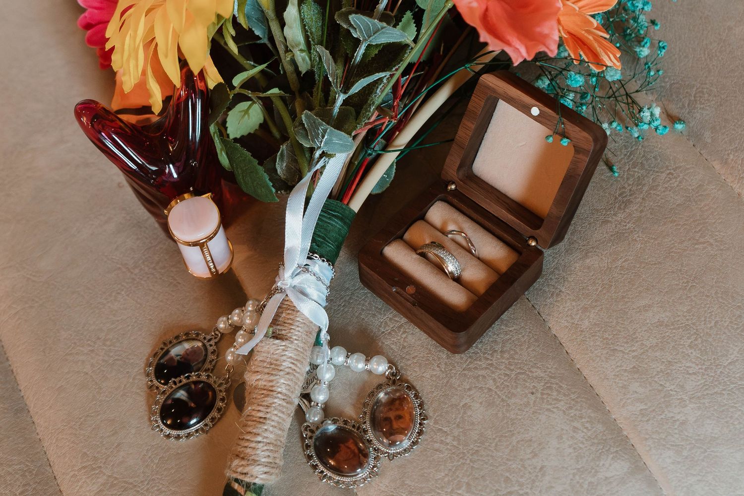 Wedding table decorations featuring colorful floral arrangements with orange and teal blooms.