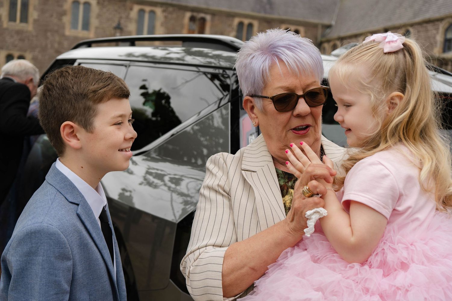Formal event photography outside a historic stone church building.