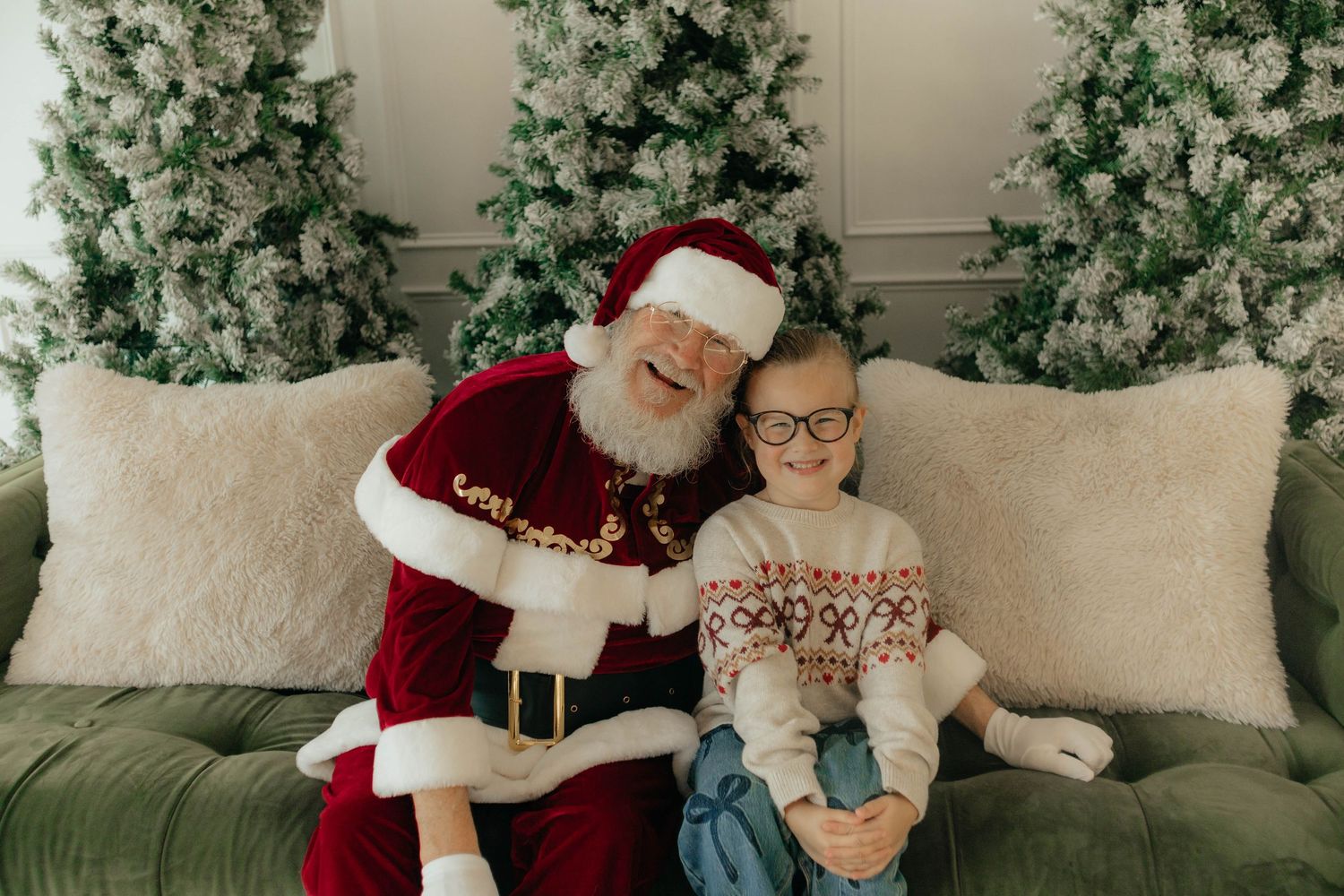 A festive holiday scene with a couch, decorative Christmas trees, and seasonal decor in a cozy living room setting.