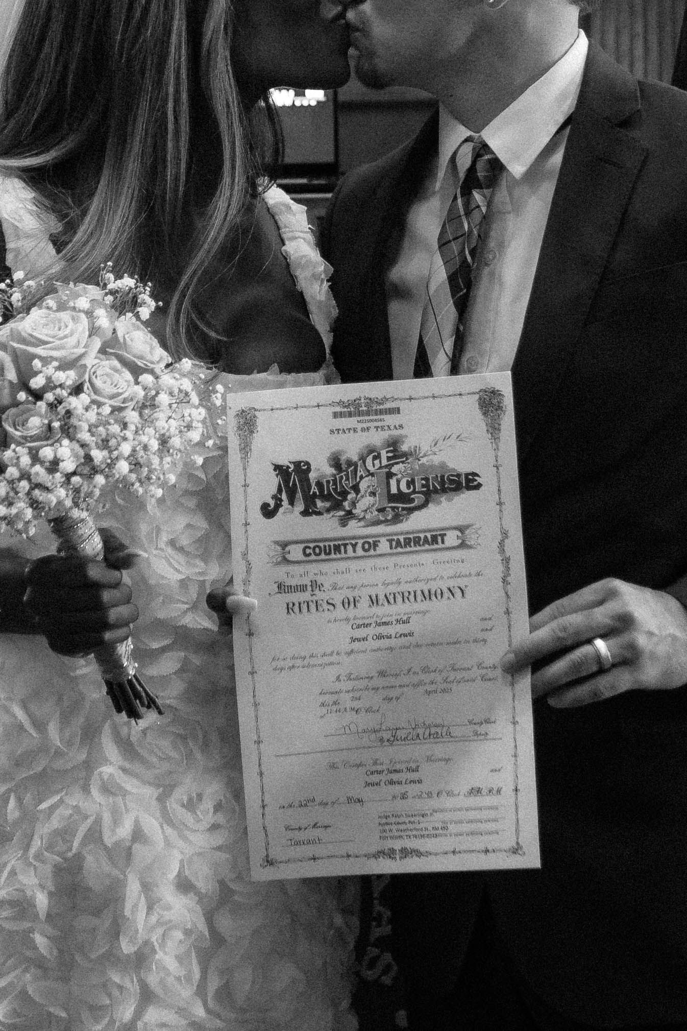 Vintage style wedding photograph showing marriage certificate and floral bouquet.