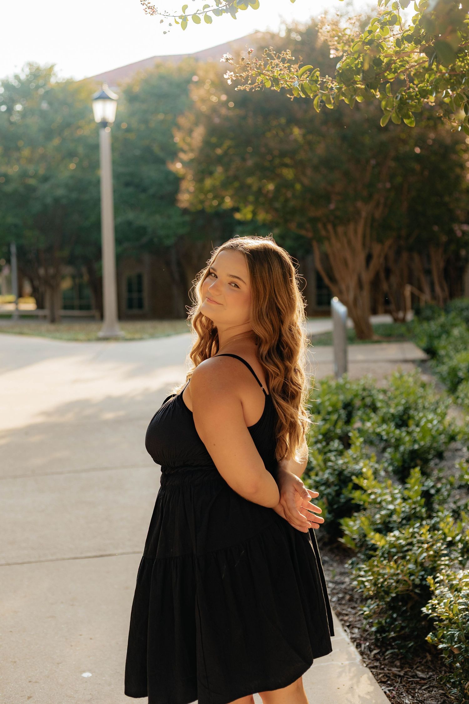Series of artistic photos showing woman in black dress against landscaped pathway and trees.
