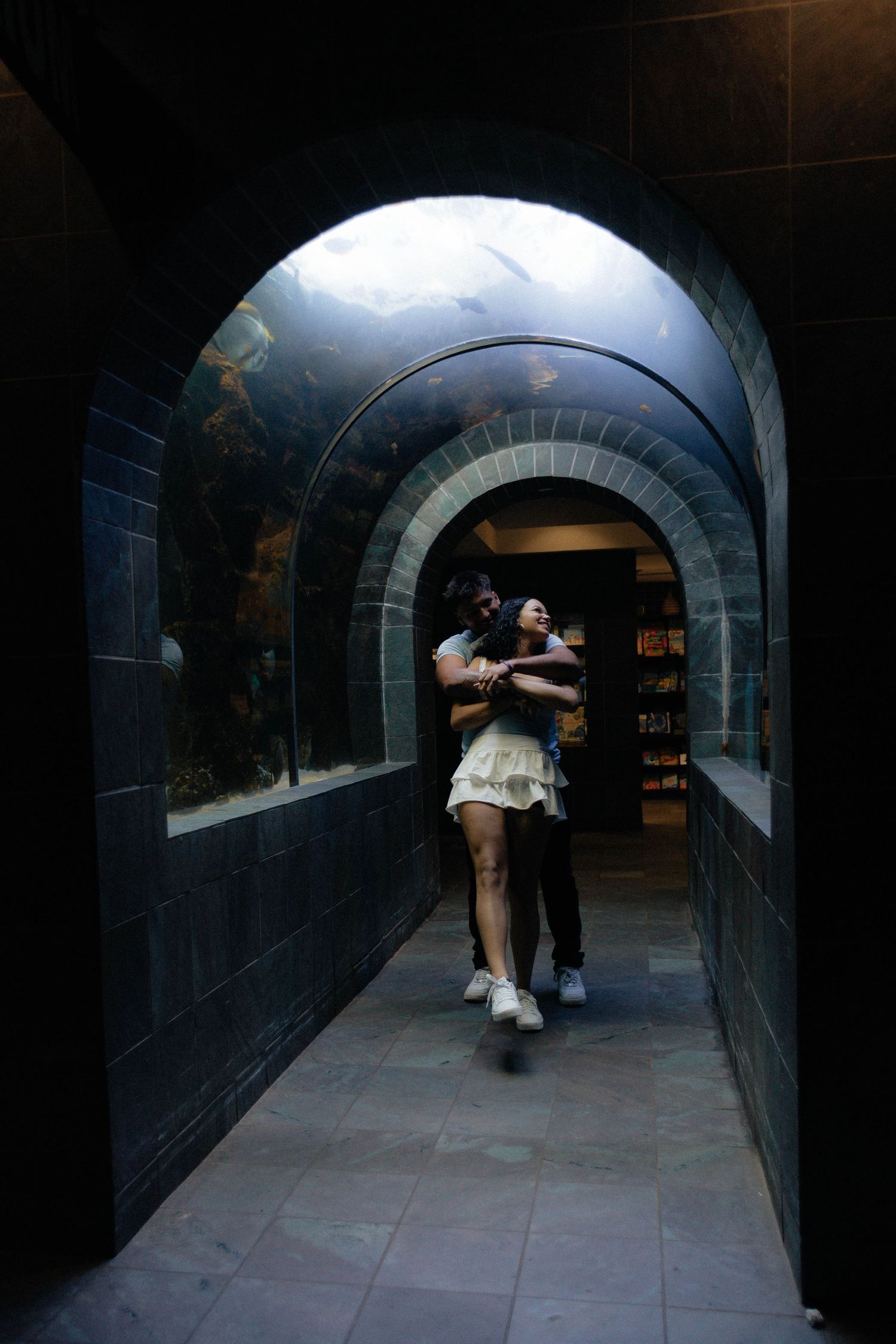 A romantic sequence in a dark stone tunnel with arched ceilings.
