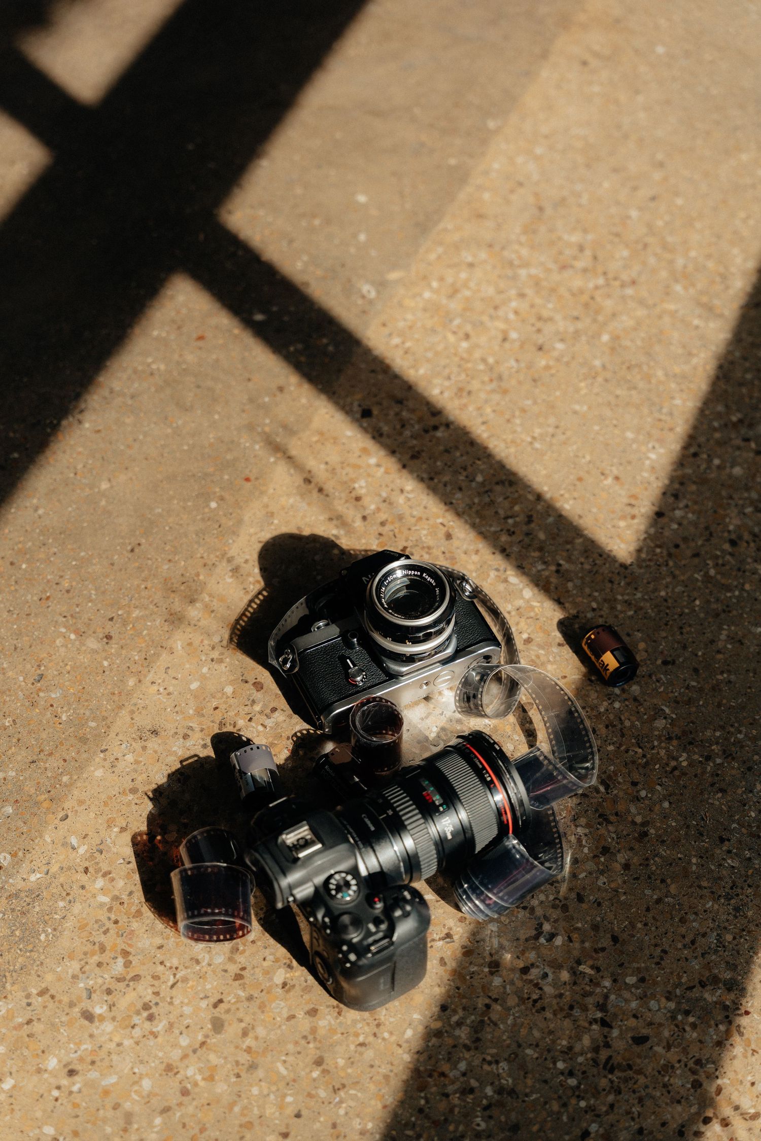 Black DSLR camera falling and tumbling in a sequence of motion shots against a textured beige surface.