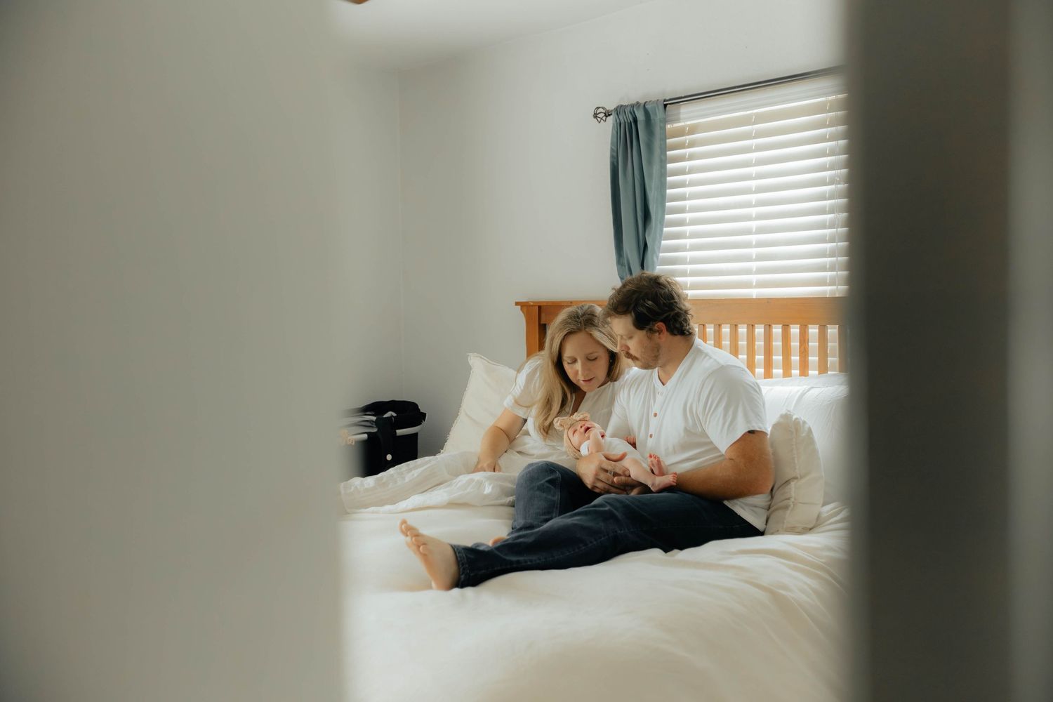 Soft, intimate moments captured through window blinds in bedroom setting.