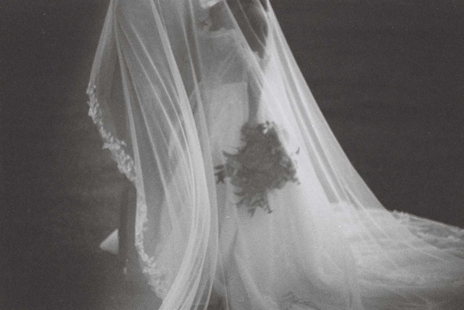 A black and white photo series shows a wedding veil flowing and moving in the wind against a dark background.
