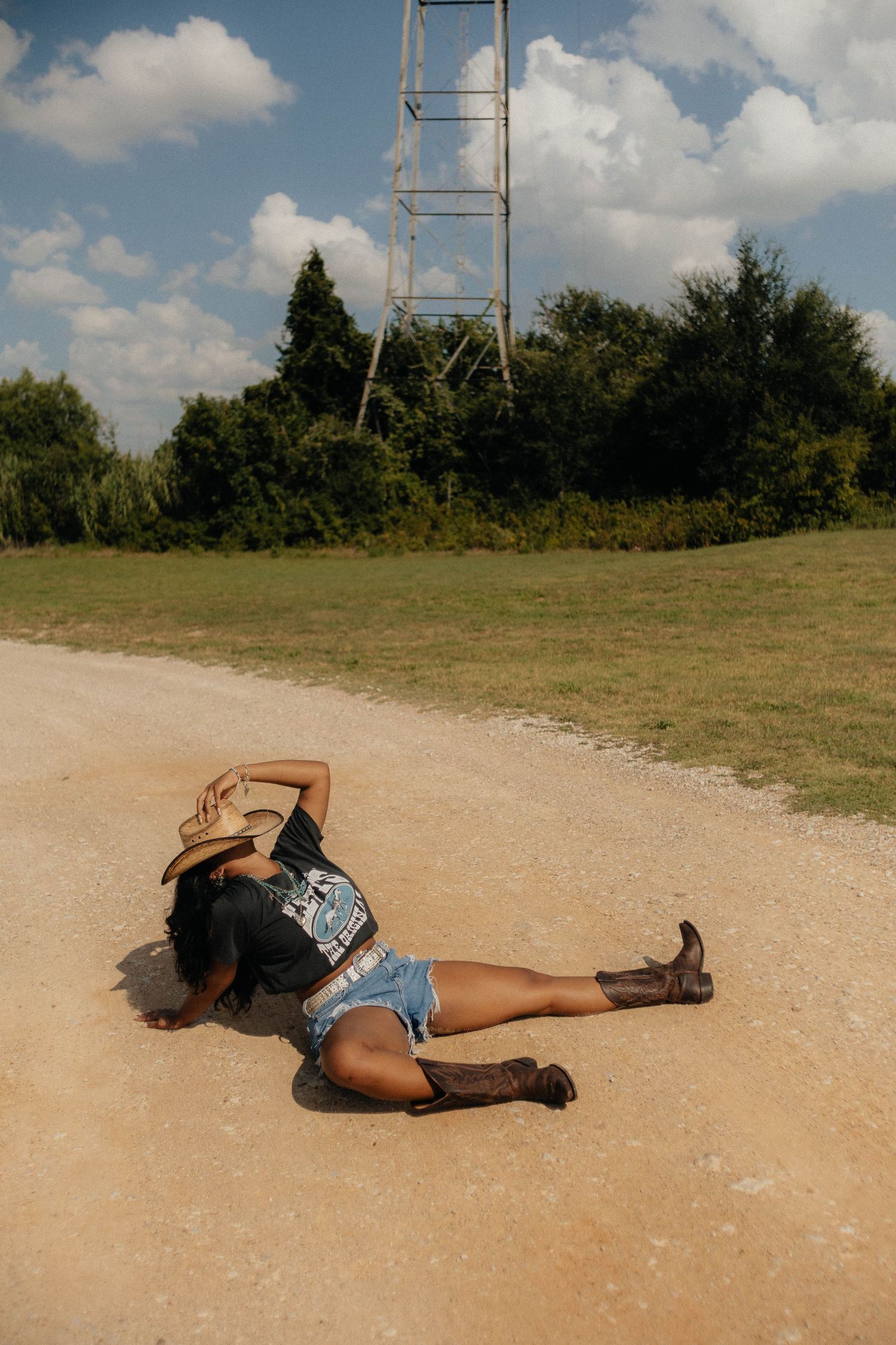 Series of dramatic poses on dusty ground near communication tower.