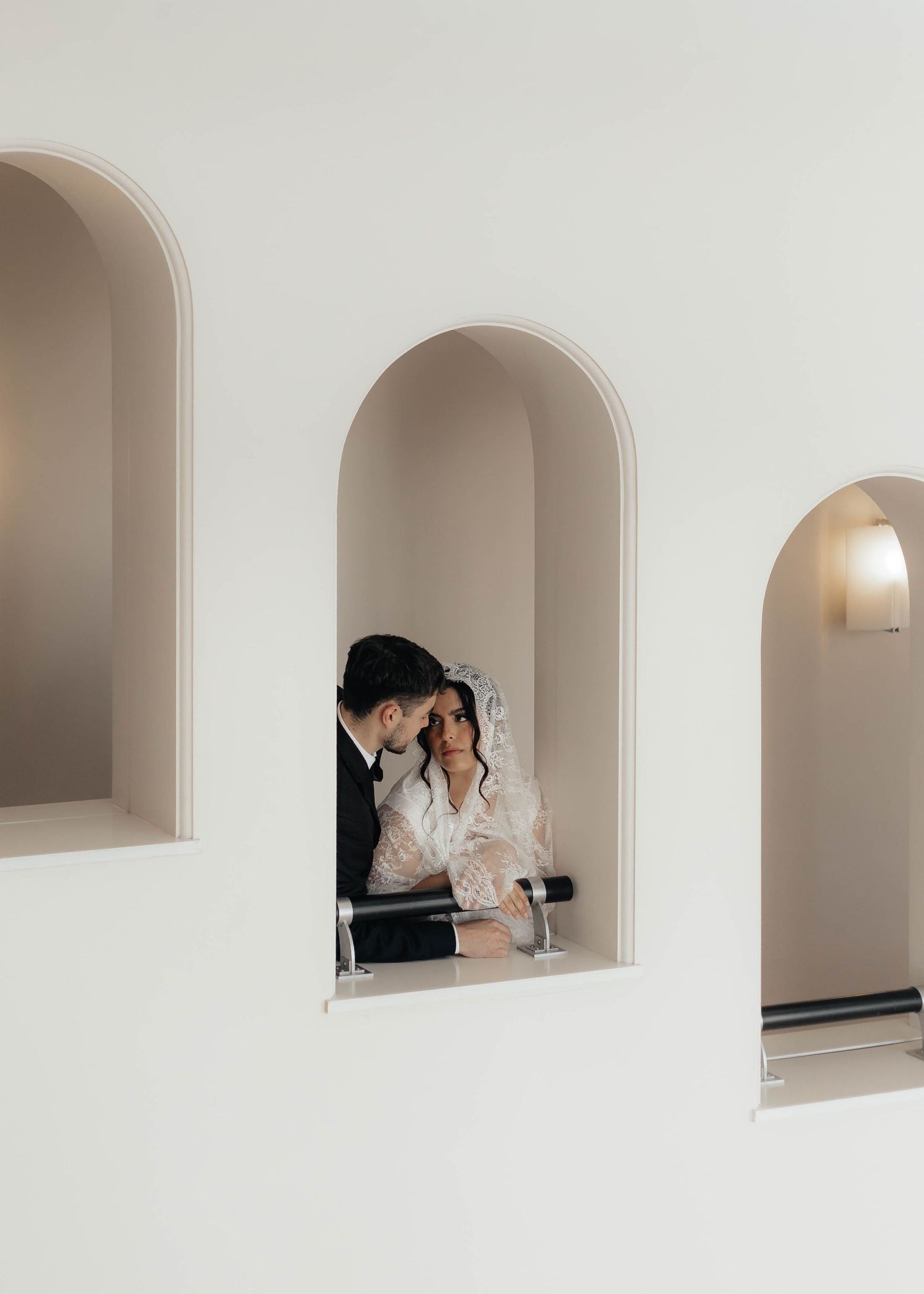 White arched alcoves with figures visible through the openings.