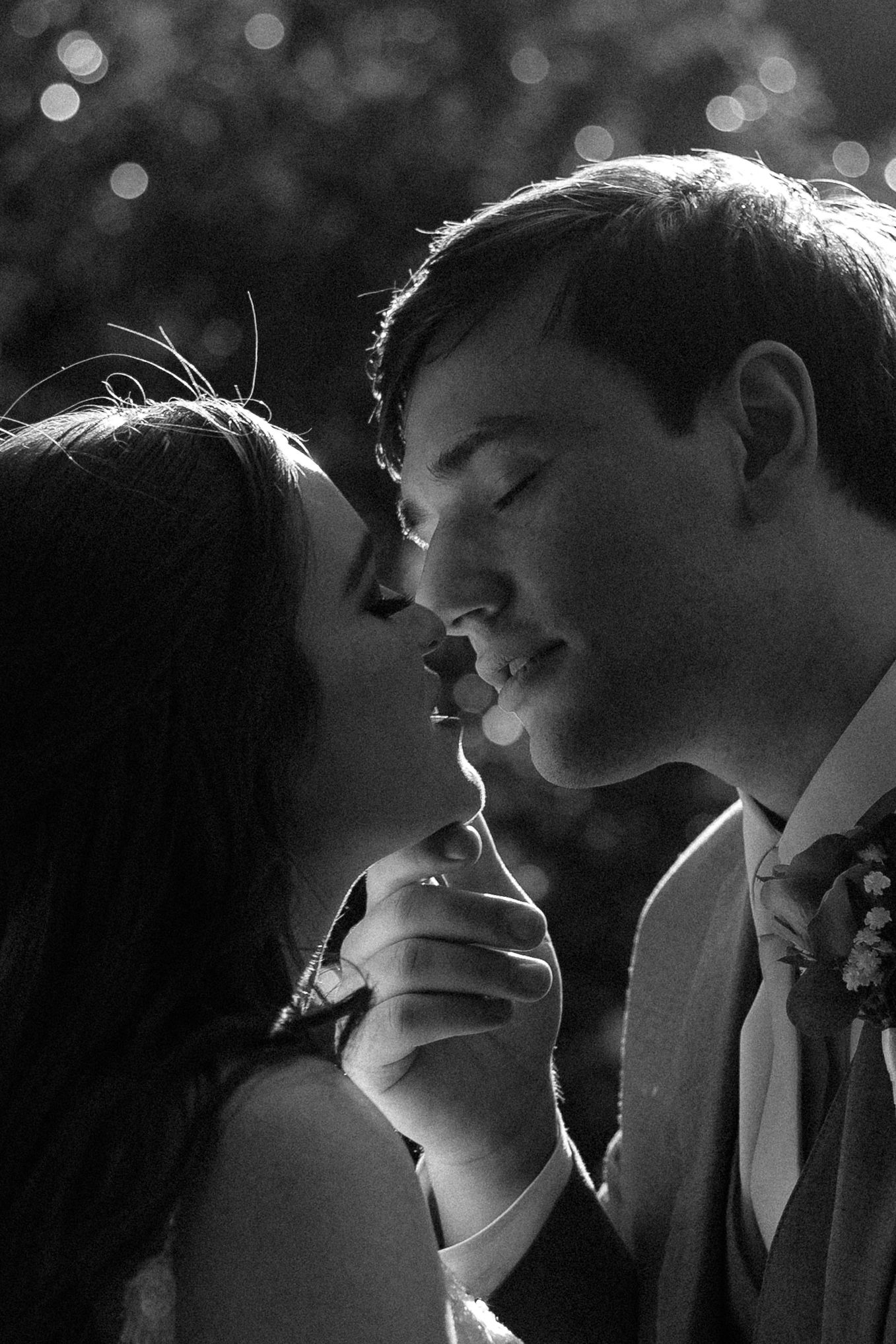A dramatic black and white close-up of a couple sharing an intimate moment.