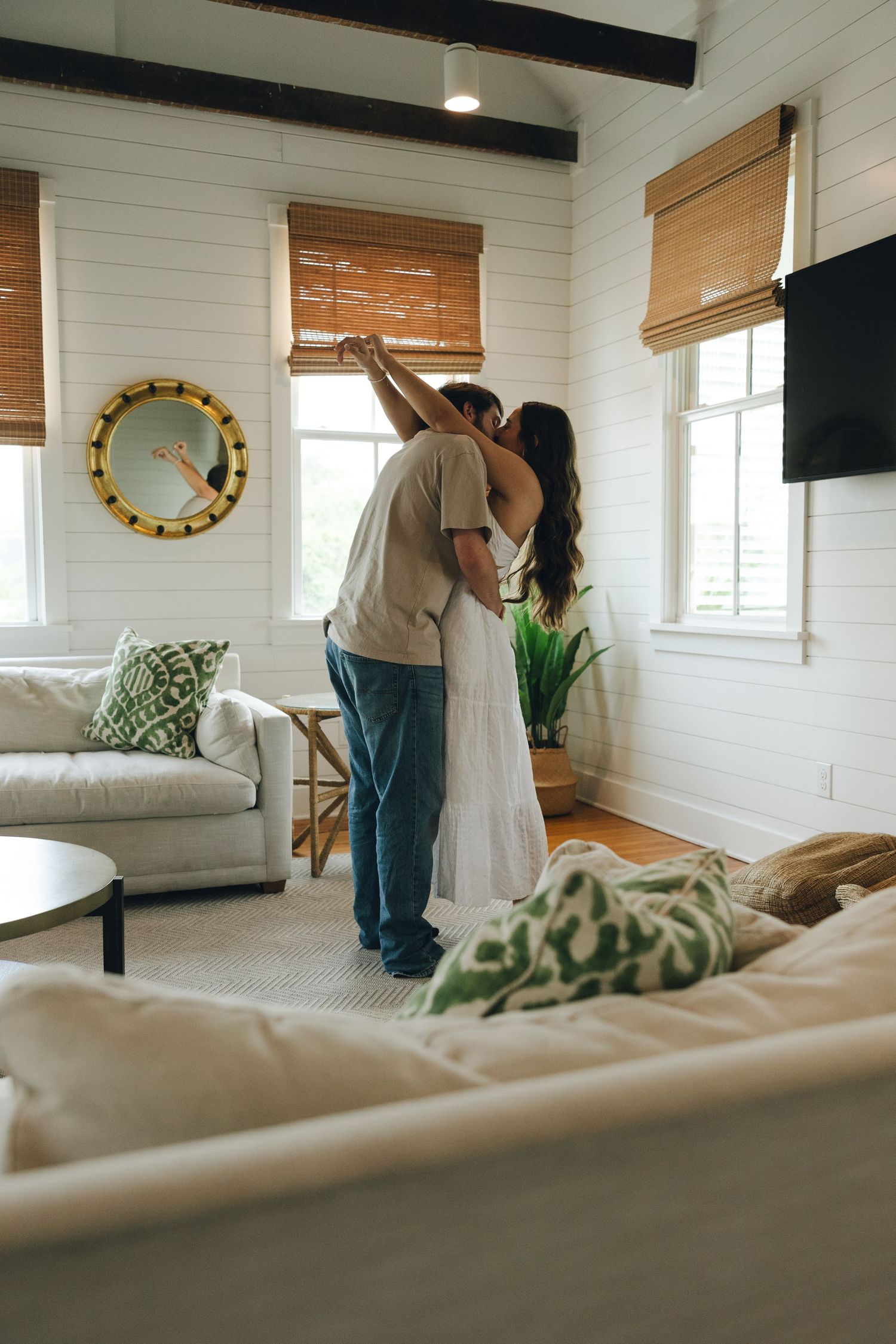 Four detailed shots of a clean modern farmhouse bedroom interior reveal talent making the bed with white linens.