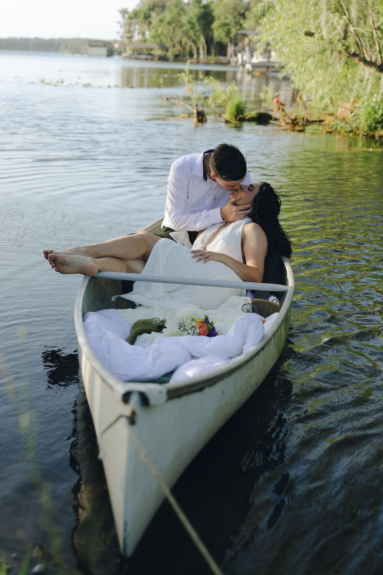 A romantic canoe ride through tranquil waters with flowers and cushions.