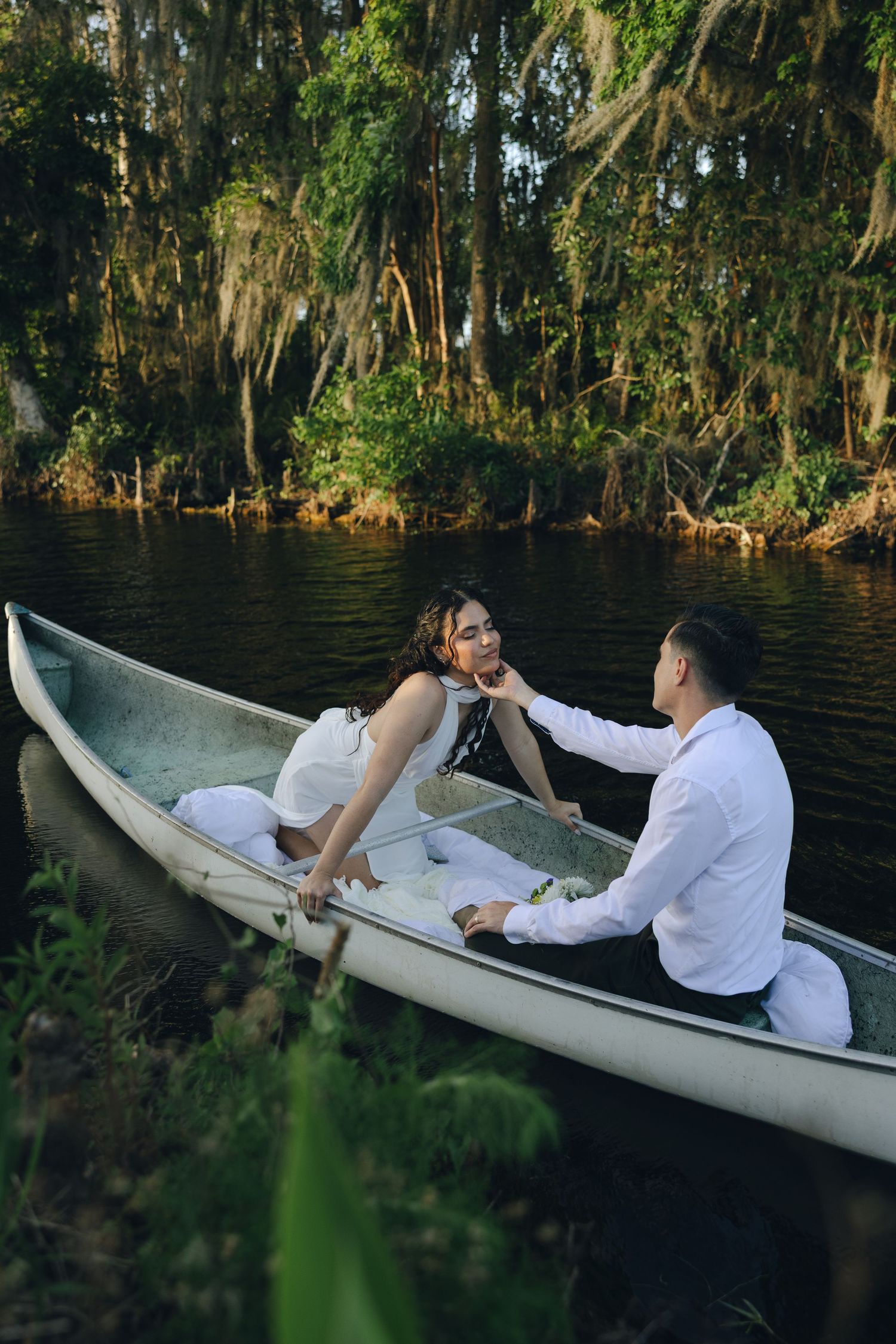 A dreamy moment shared in a white canoe surrounded by moss-draped cypress trees.