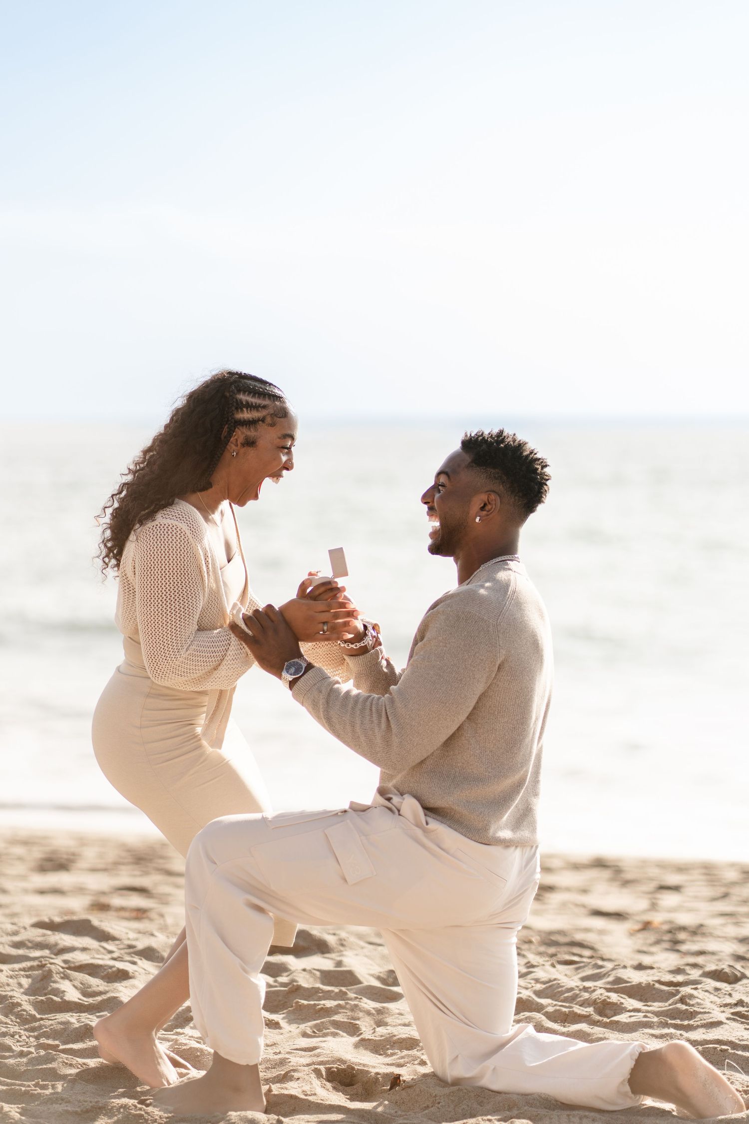 Romantic couple enjoying their engagement at Point Dume Beach, capturing love, ocean views, and golden California coastal vibes.