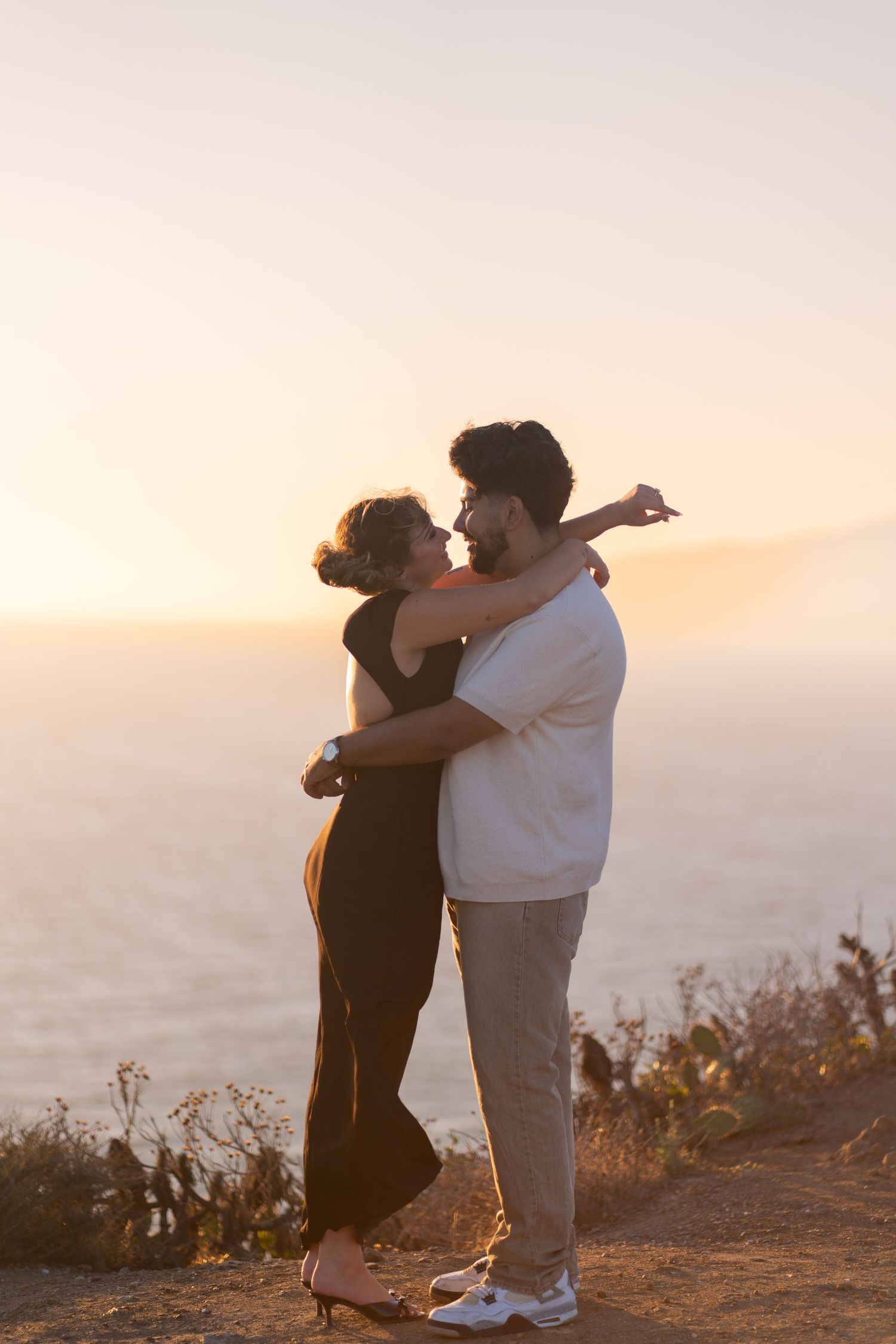 Couple kissing at the top of Point Dume, Malibu to celebrate their engagement