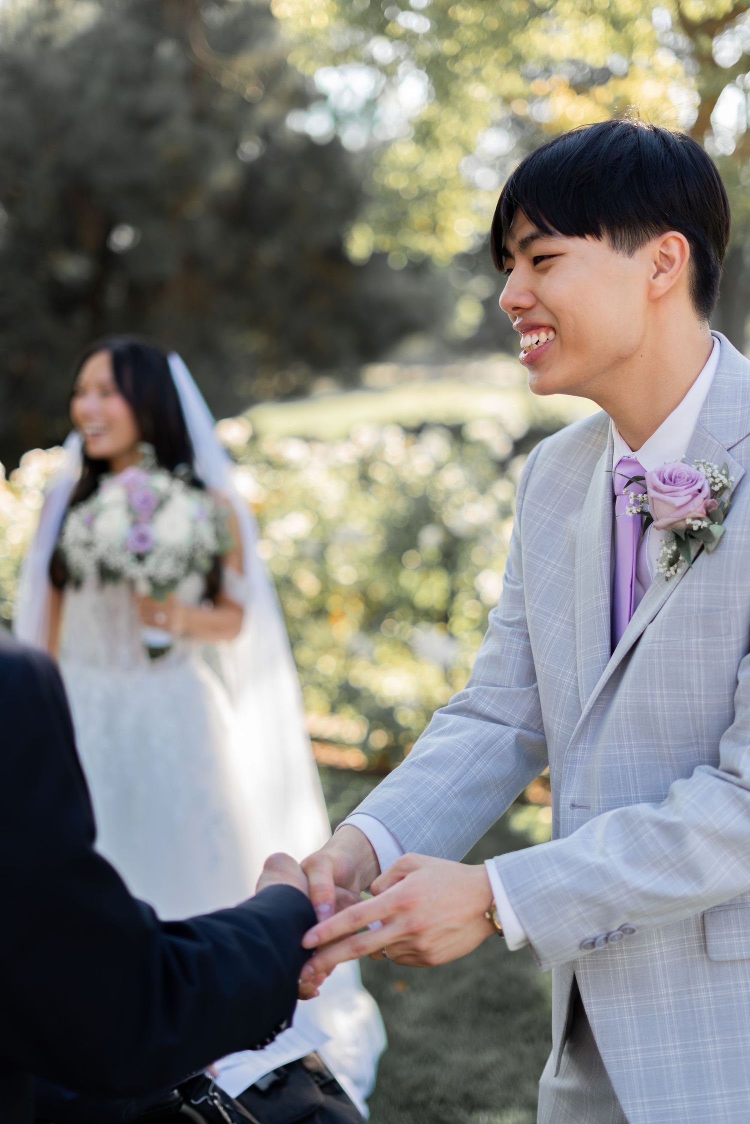 Groom warmly greeting guests and sharing joyful moments on his wedding day.