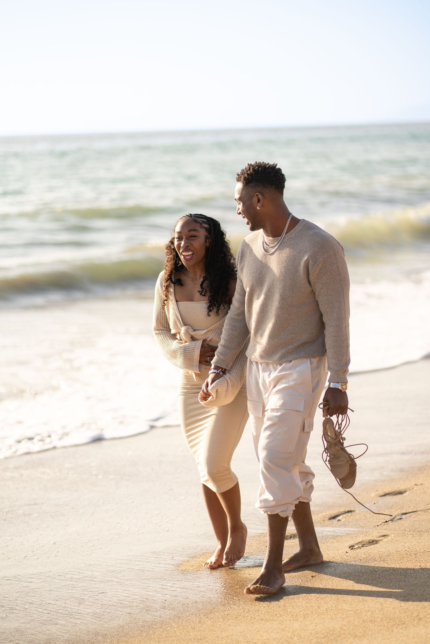 Romantic couple enjoying their engagement at Point Dume Beach, capturing love, ocean views, and golden California coastal vibes.