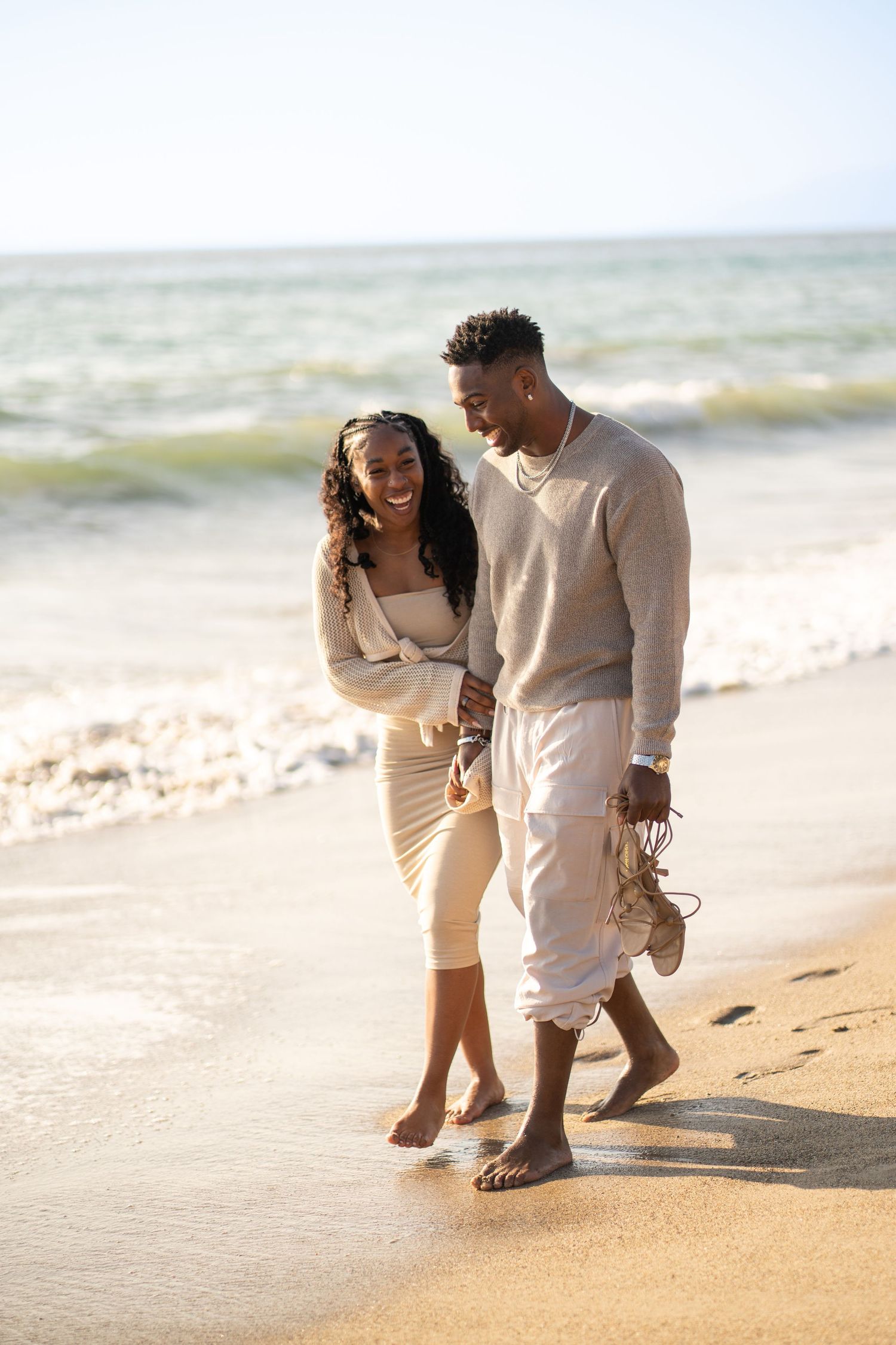 Romantic couple enjoying their engagement at Point Dume Beach, capturing love, ocean views, and golden California coastal vibes.