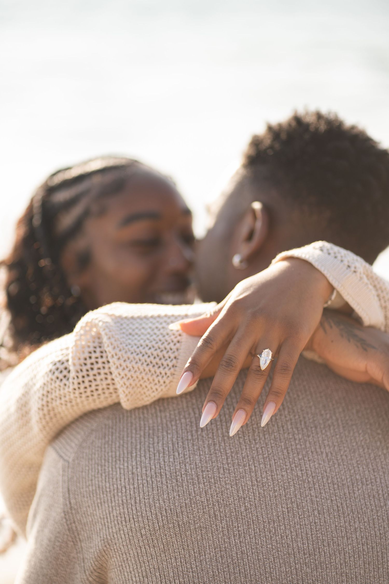 Romantic couple enjoying their engagement at Point Dume Beach, capturing love, ocean views, and golden California coastal vibes.