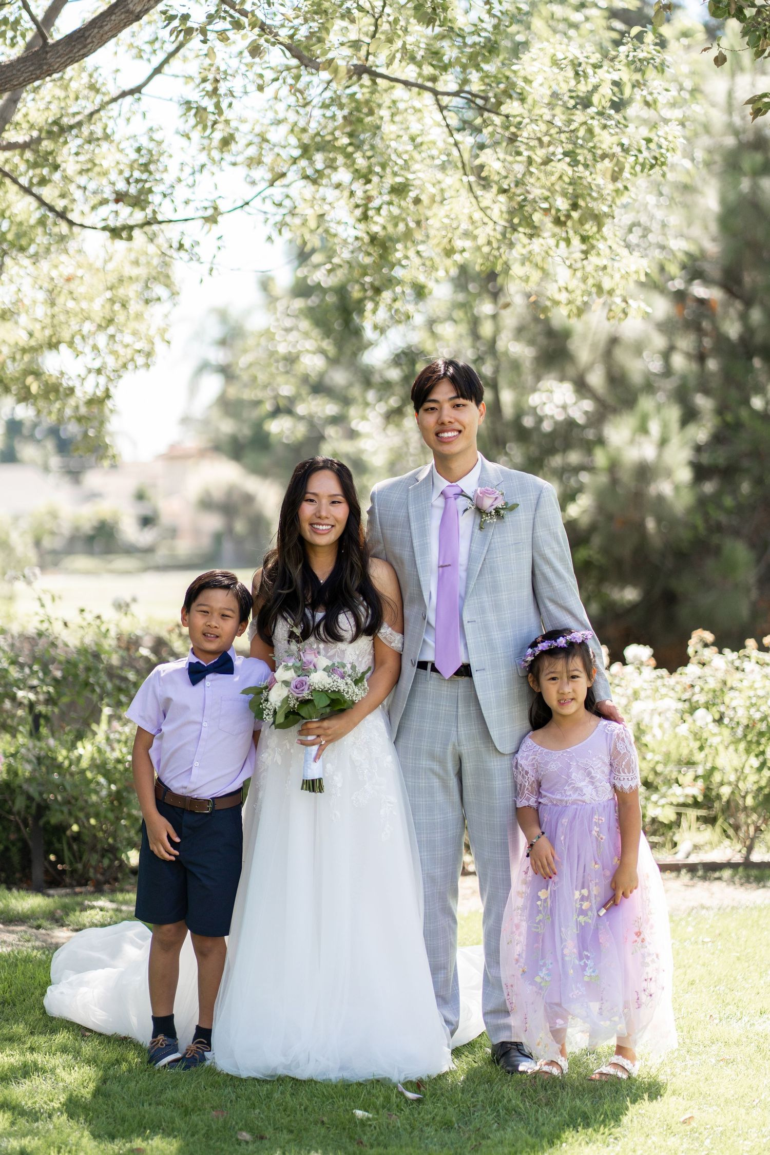 Bride and groom capturing cherished family photos surrounded by their loving relatives.