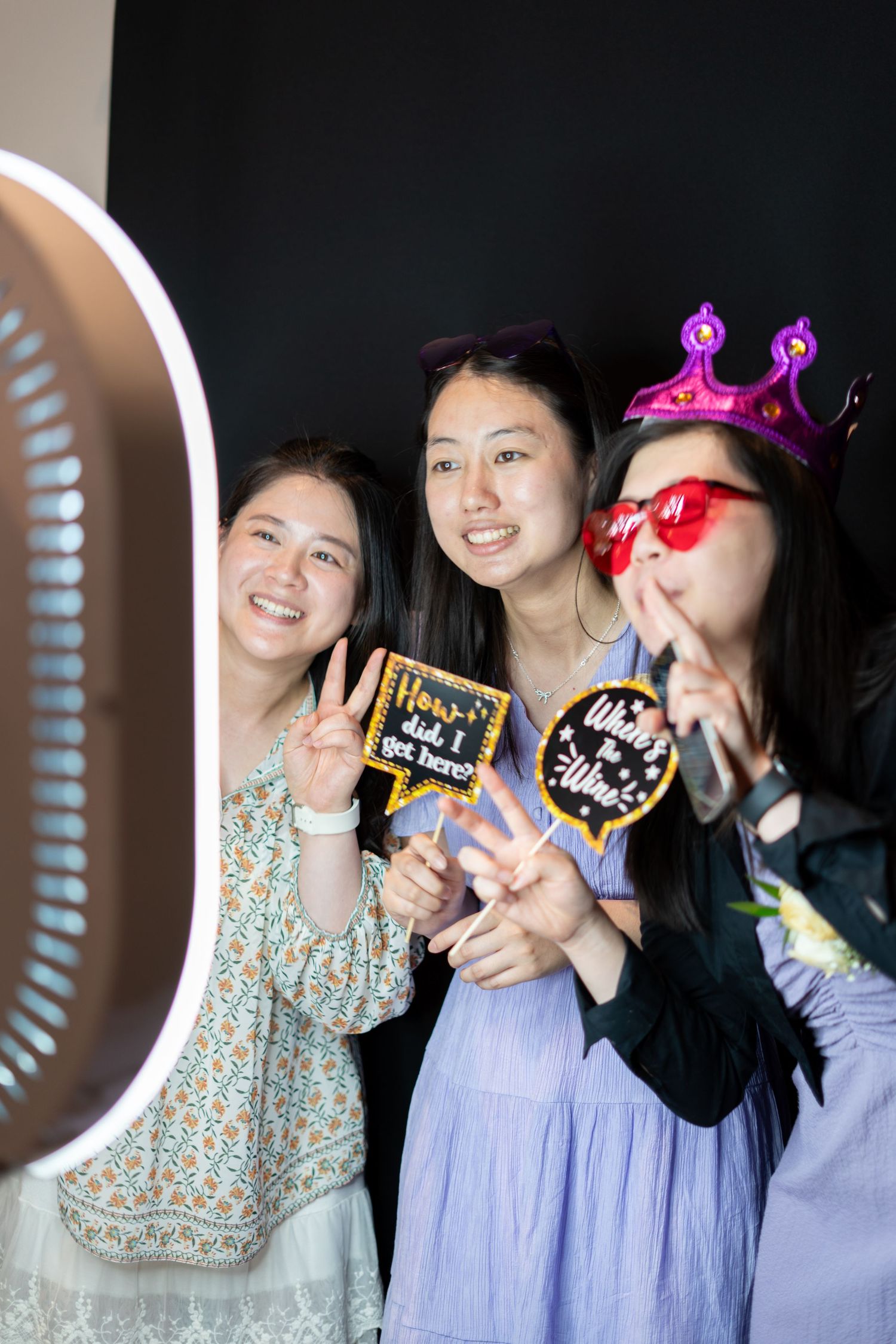 Bride and wedding guest laughing together in a photo booth during the reception
