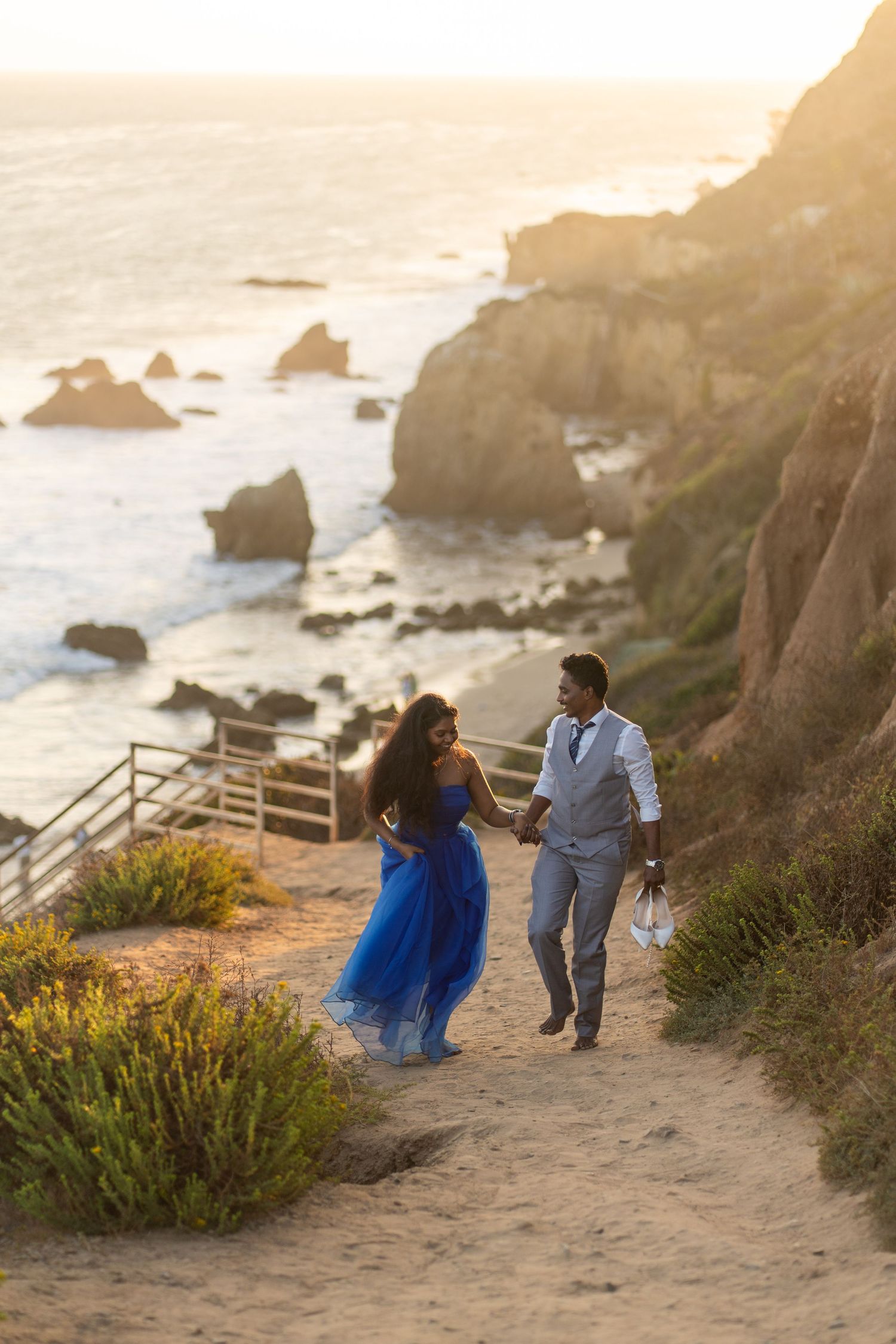 Engaged couple strolling up El Matador Beach in Malibu after their photoshoot