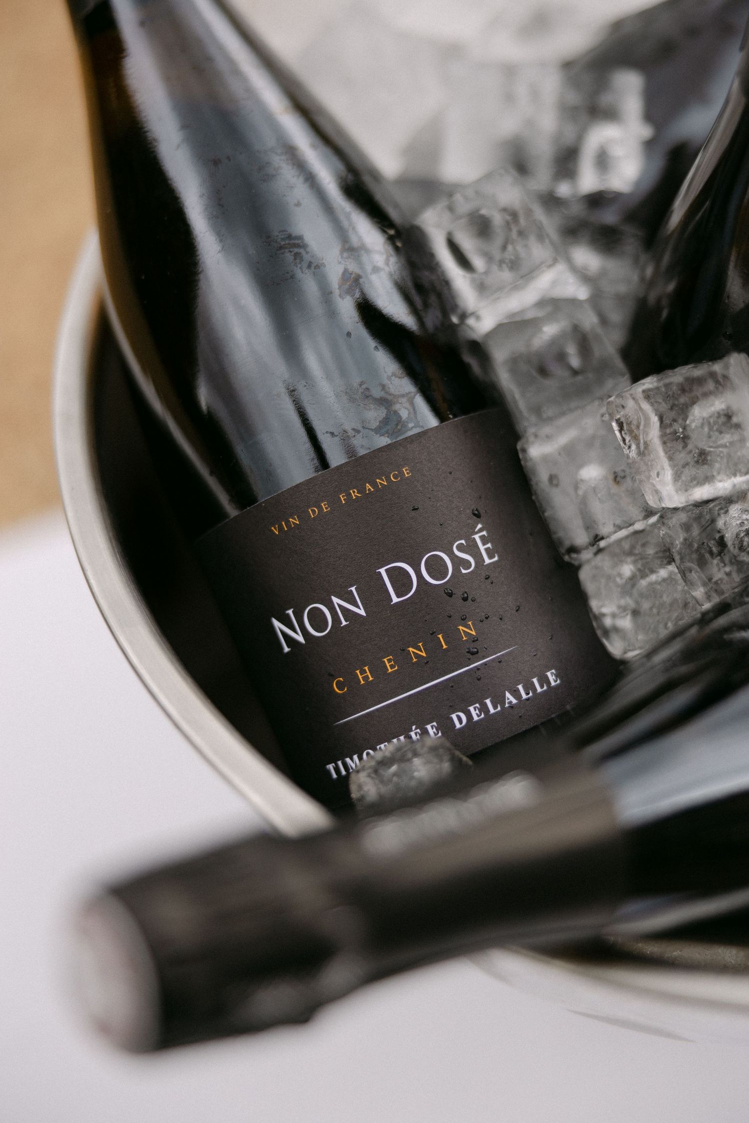 Bottle of Non Dose Chenin sparkling wine by Timothee Delalle chilling in an ice bucket at a wedding.