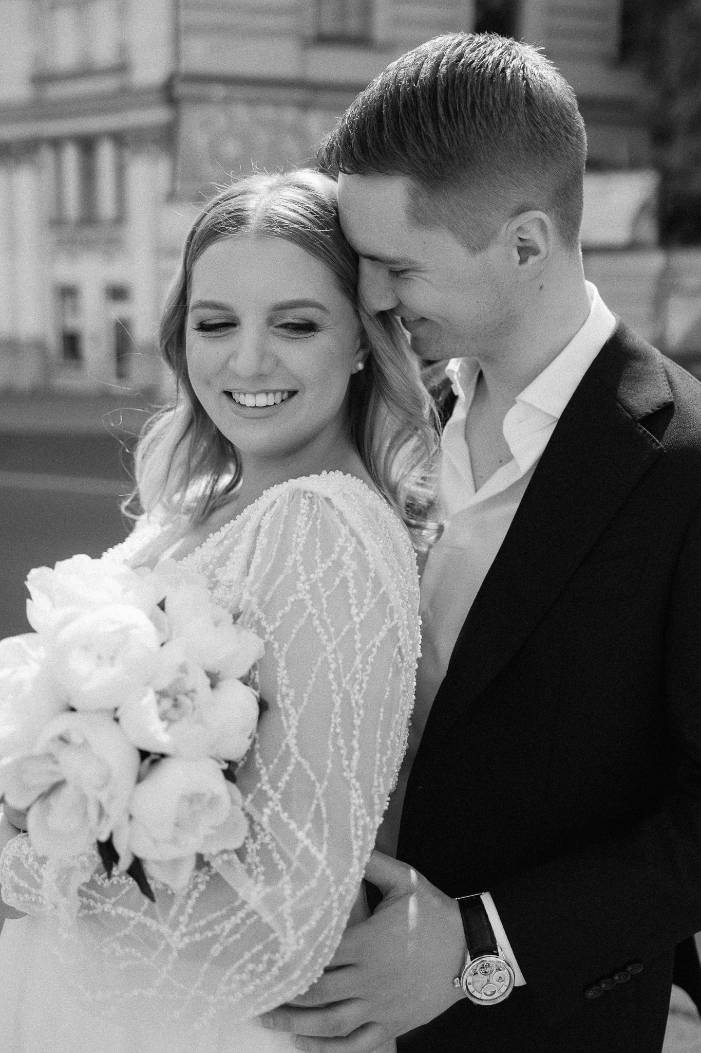 Black and white romantic wedding portrait of couple with white bouquet.