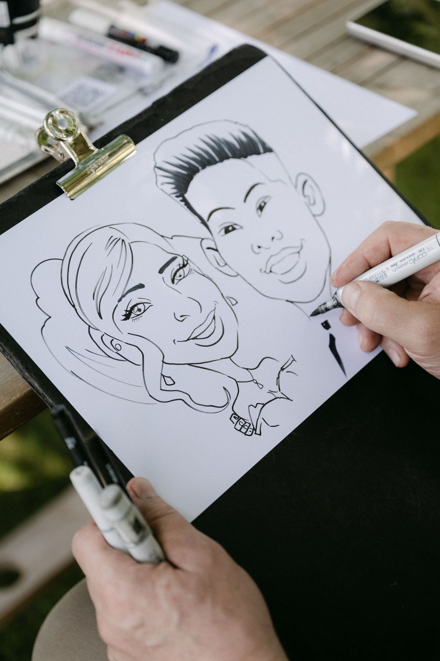 Artist drawing caricature of bride and groom couple at wedding reception.