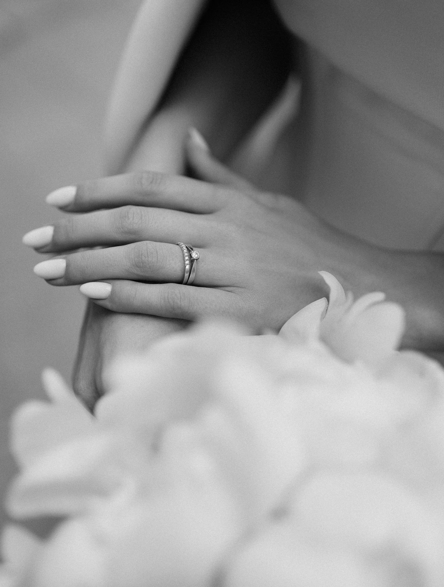 Close up of wedding ring on hand with soft focus black and white photography.