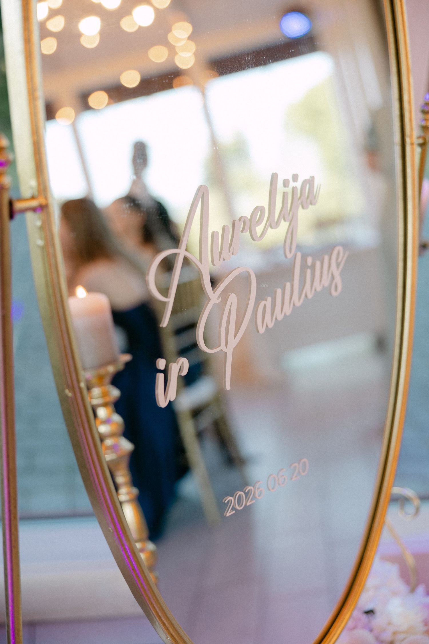 Elegant gold mirror wedding sign reading Aurelija ir Paulius with date 2023.09.70 at reception.