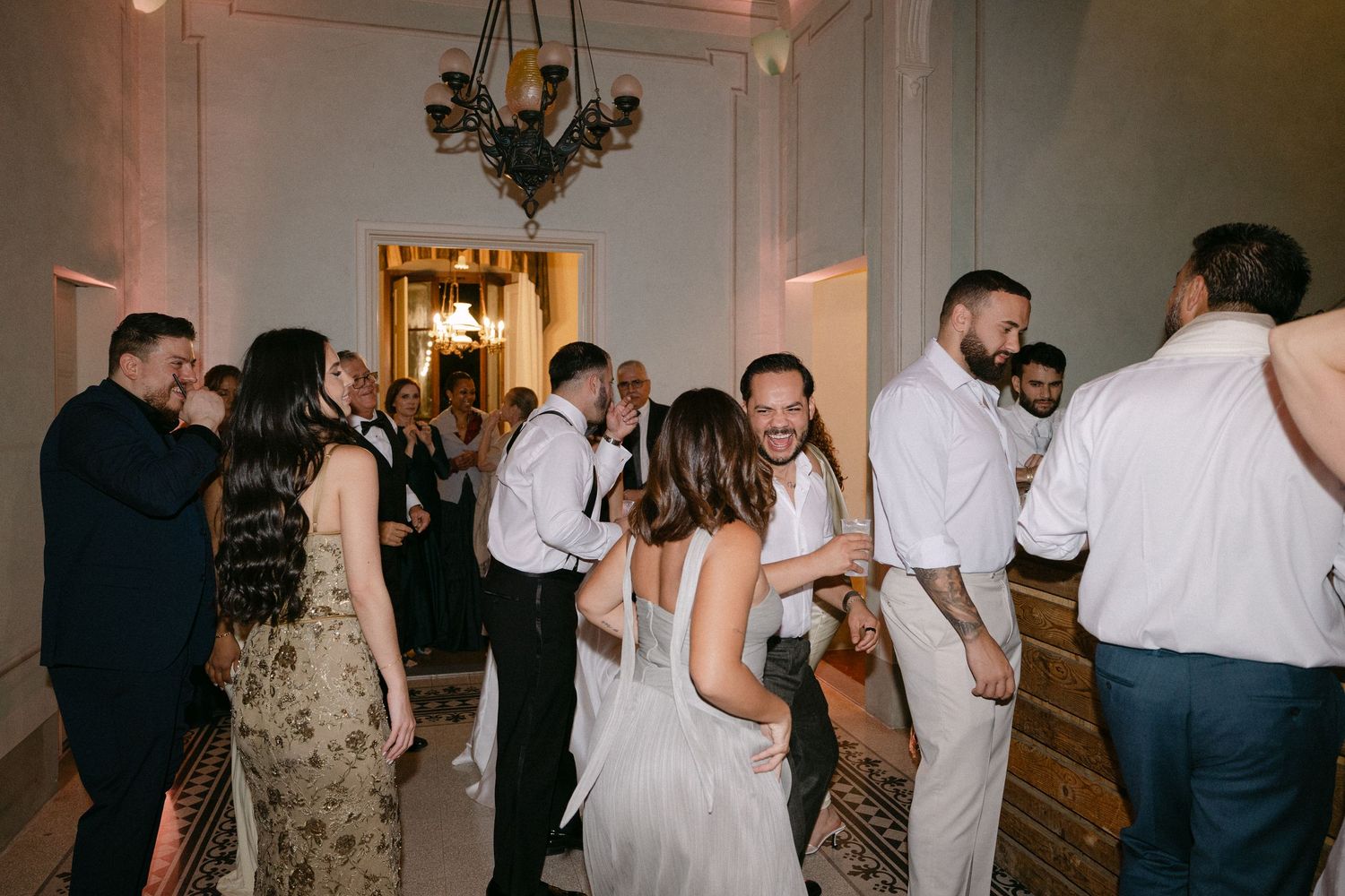Wedding guests dancing and celebrating together in elegant venue during lively reception party.
