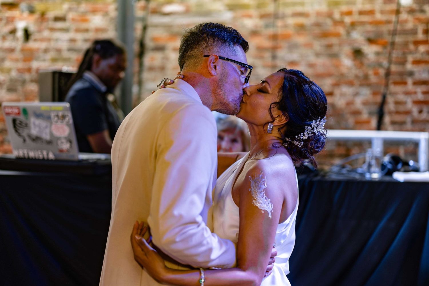 A romantic dance moment captured in front of an exposed brick wall.
